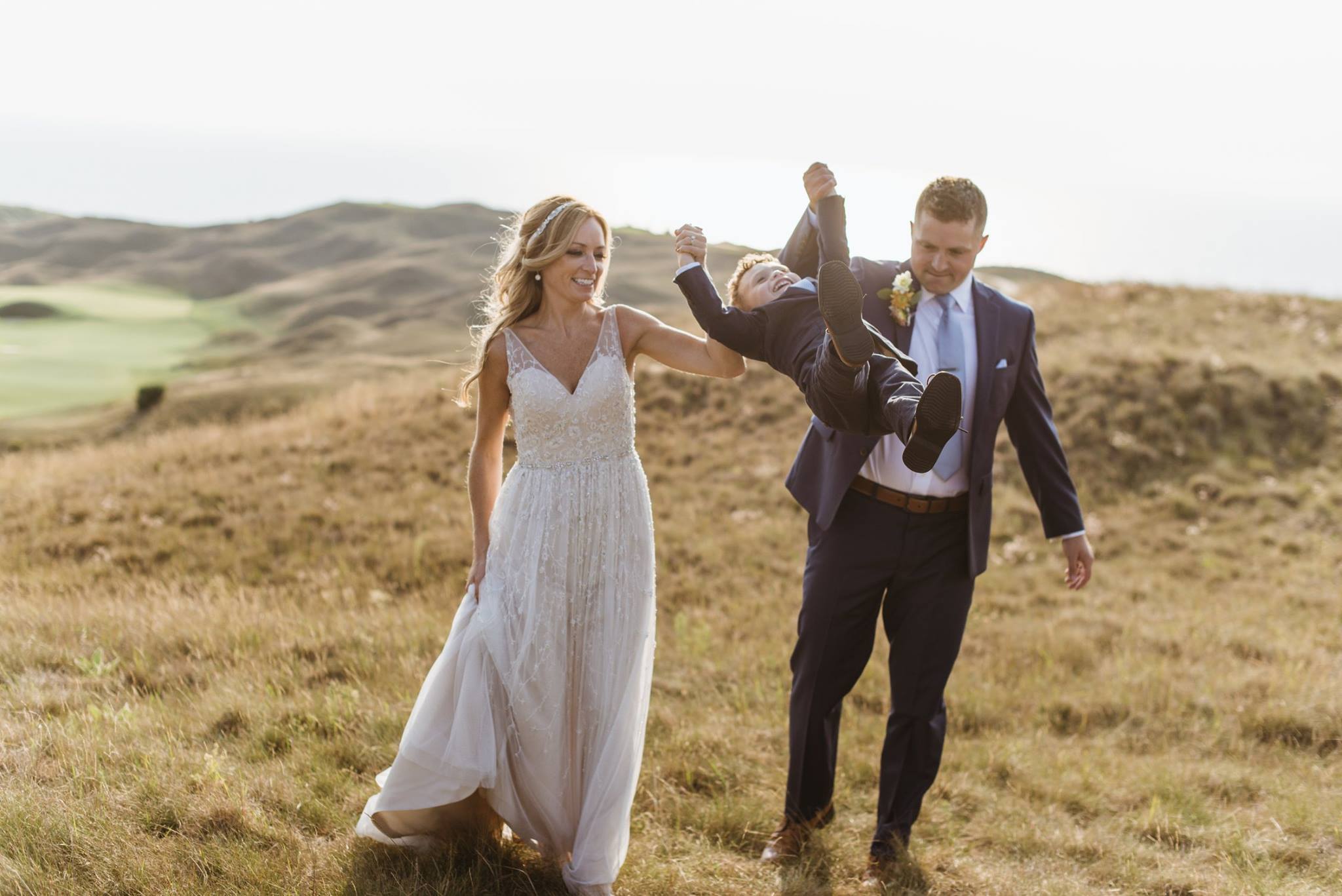 bride and groom swinging son at wedding in arcadia michigan
