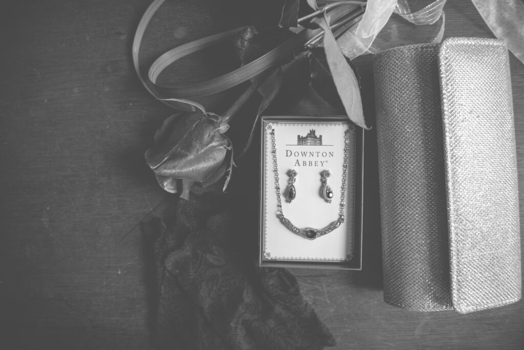 a box of antique jewelry, a rose, and a wallet sitting on a table in downtown traverse city. Photo by traverse city wedding photographer lina lavonne photography