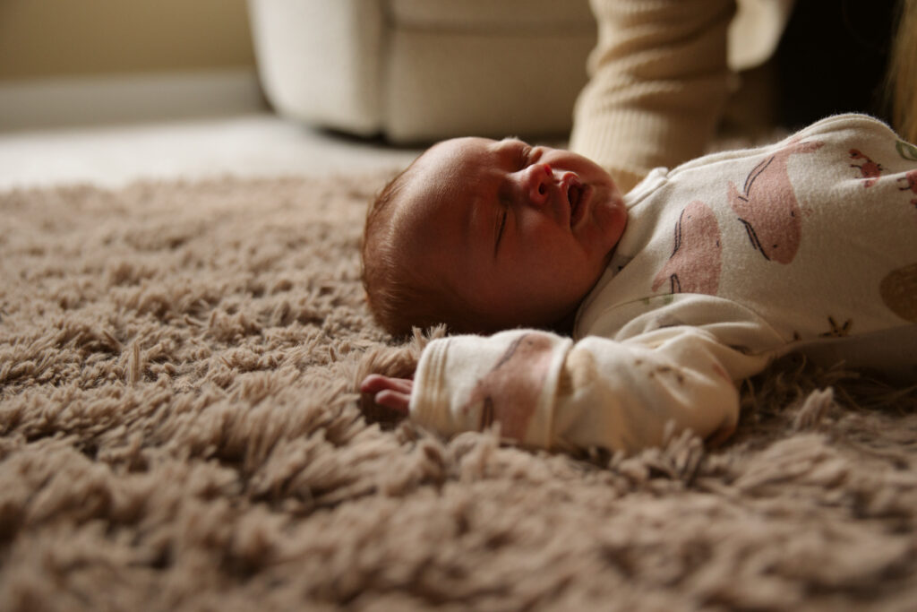 baby laying on blanket during newborn portraits in traverse city