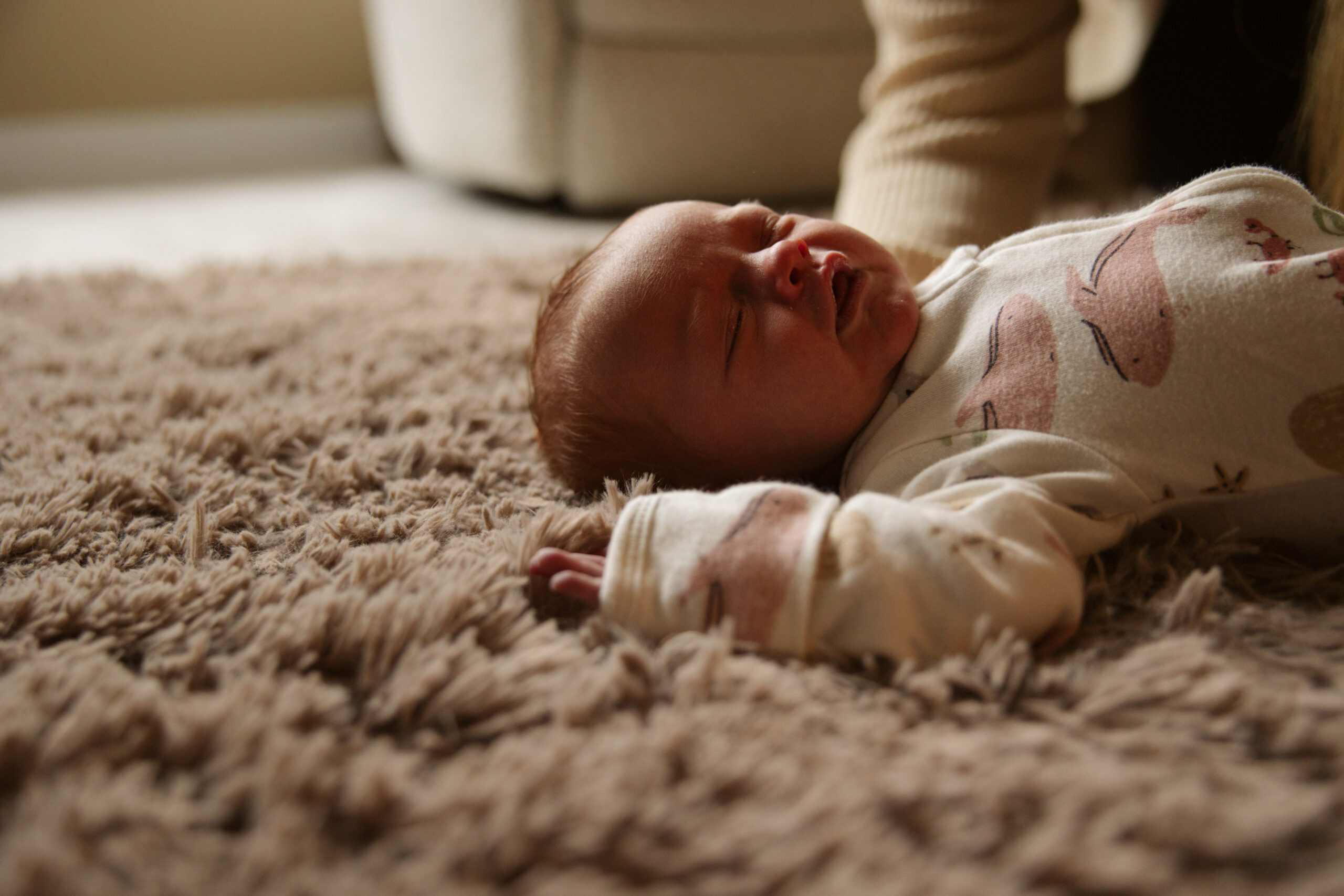 baby laying on blanket during newborn portraits in traverse city