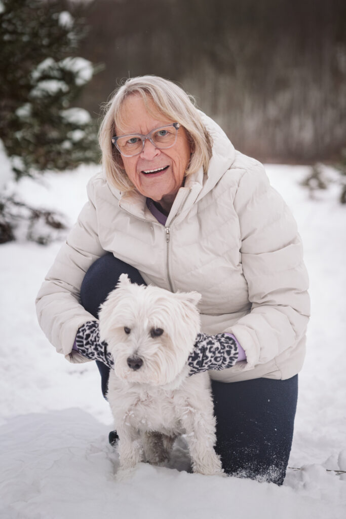 woman and her dog cuddling during winter portraits in traverse city