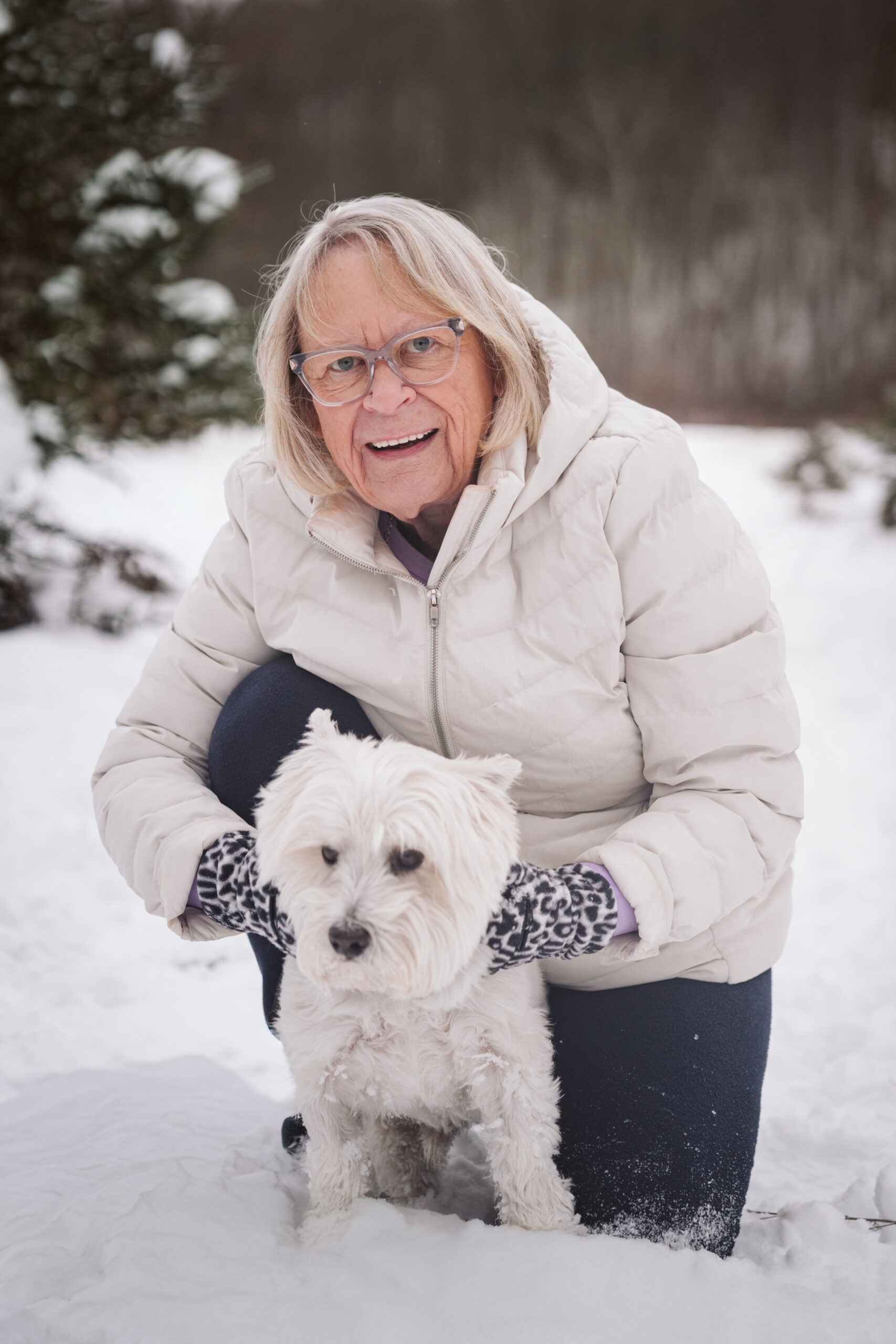 woman and her dog cuddling during winter portraits in traverse city