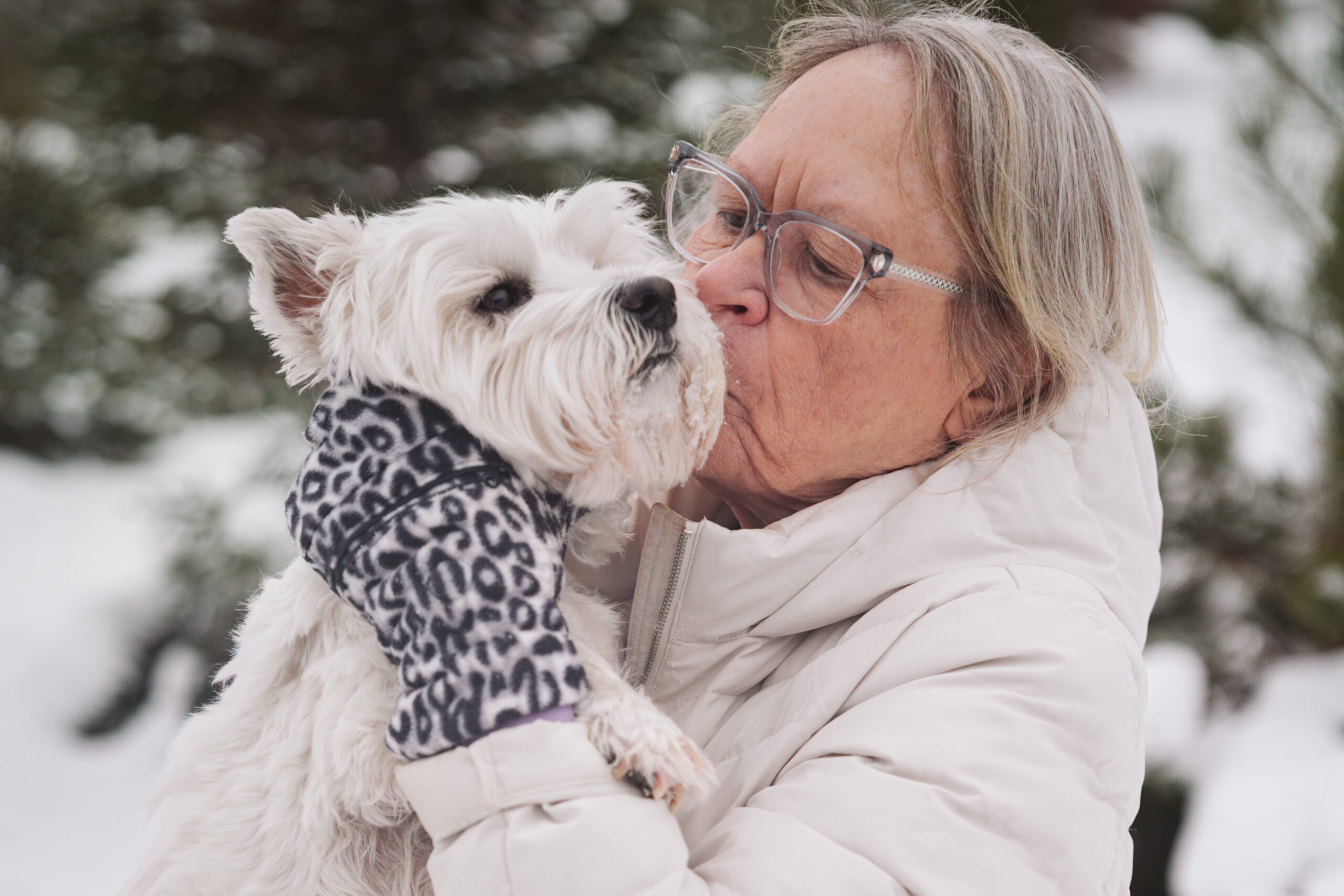 woman and her dog cuddling during winter portraits in traverse city
