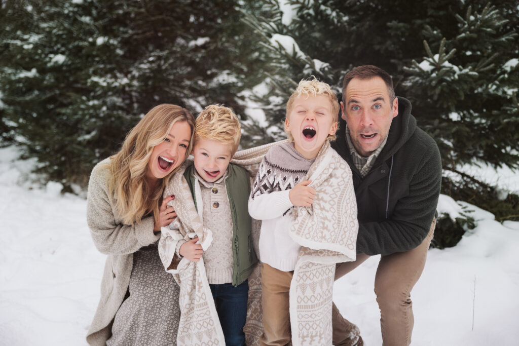 family of four making faces during christmas photos in traverse city