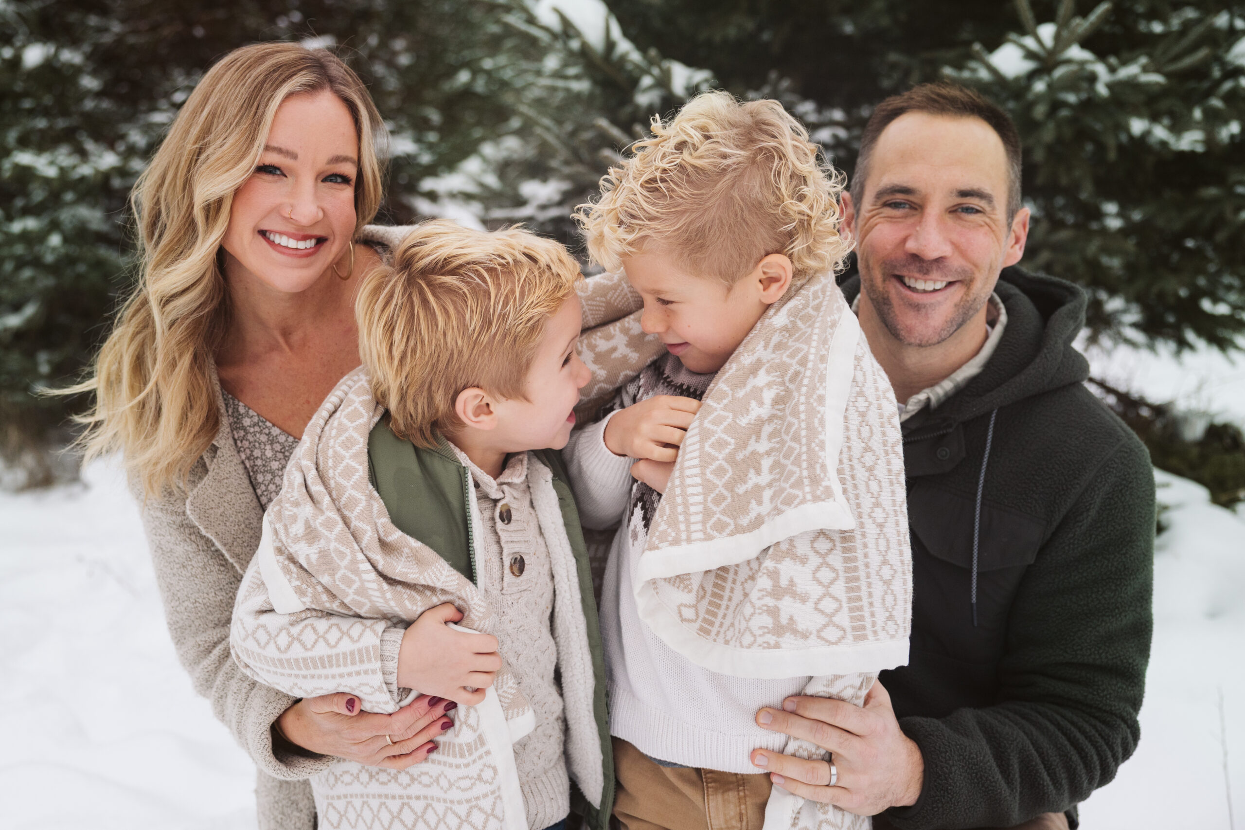 family huddled together with little boys laughing during family photos in traverse city