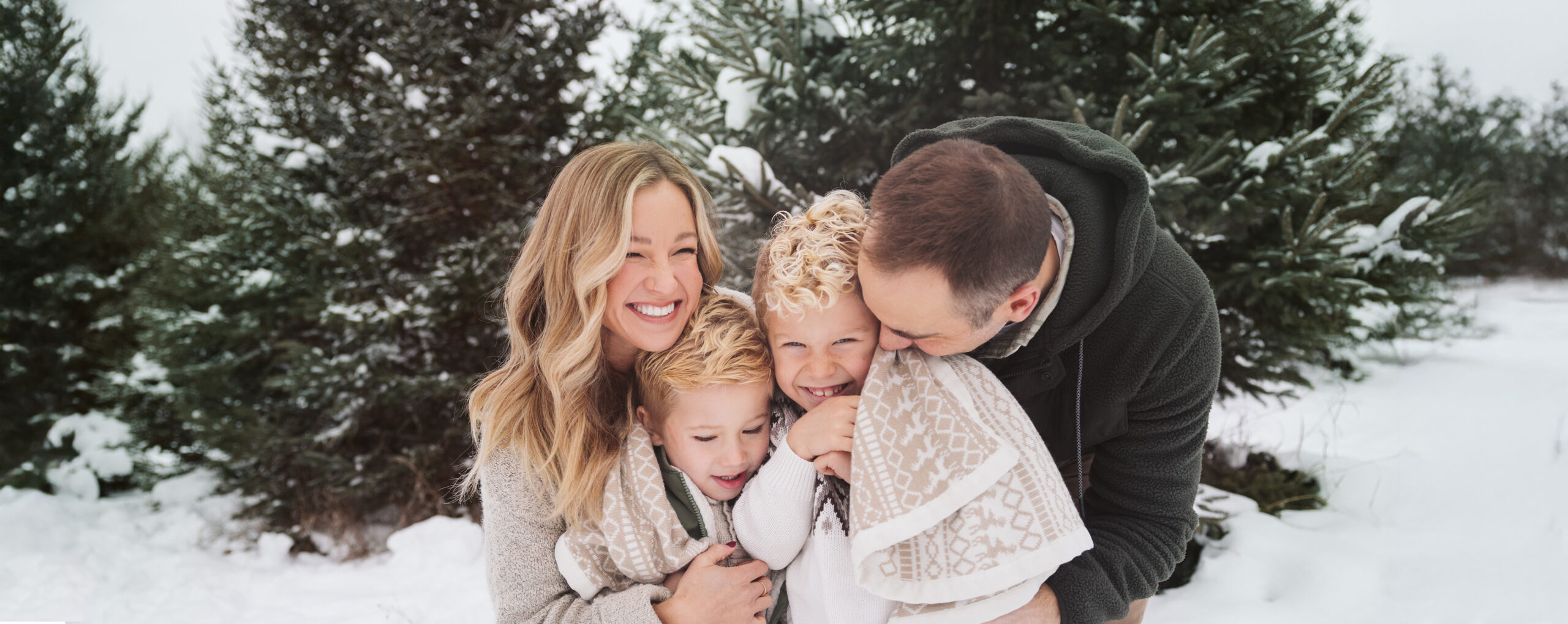 family cuddling in the snow during family photos in traverse city