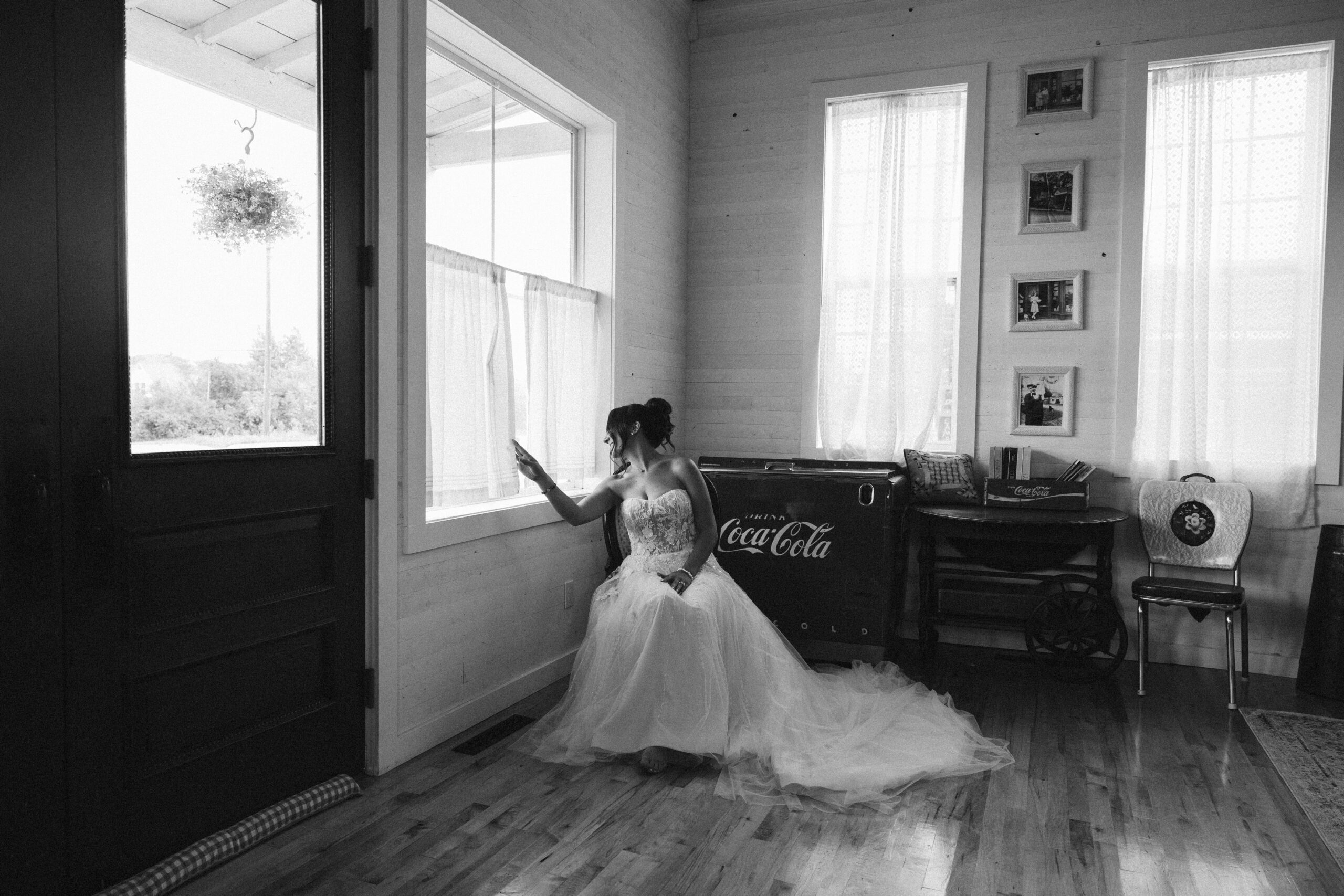 bride peeking out window at general store at a general store at wedding in east jordan boathouse on lake charlevoix