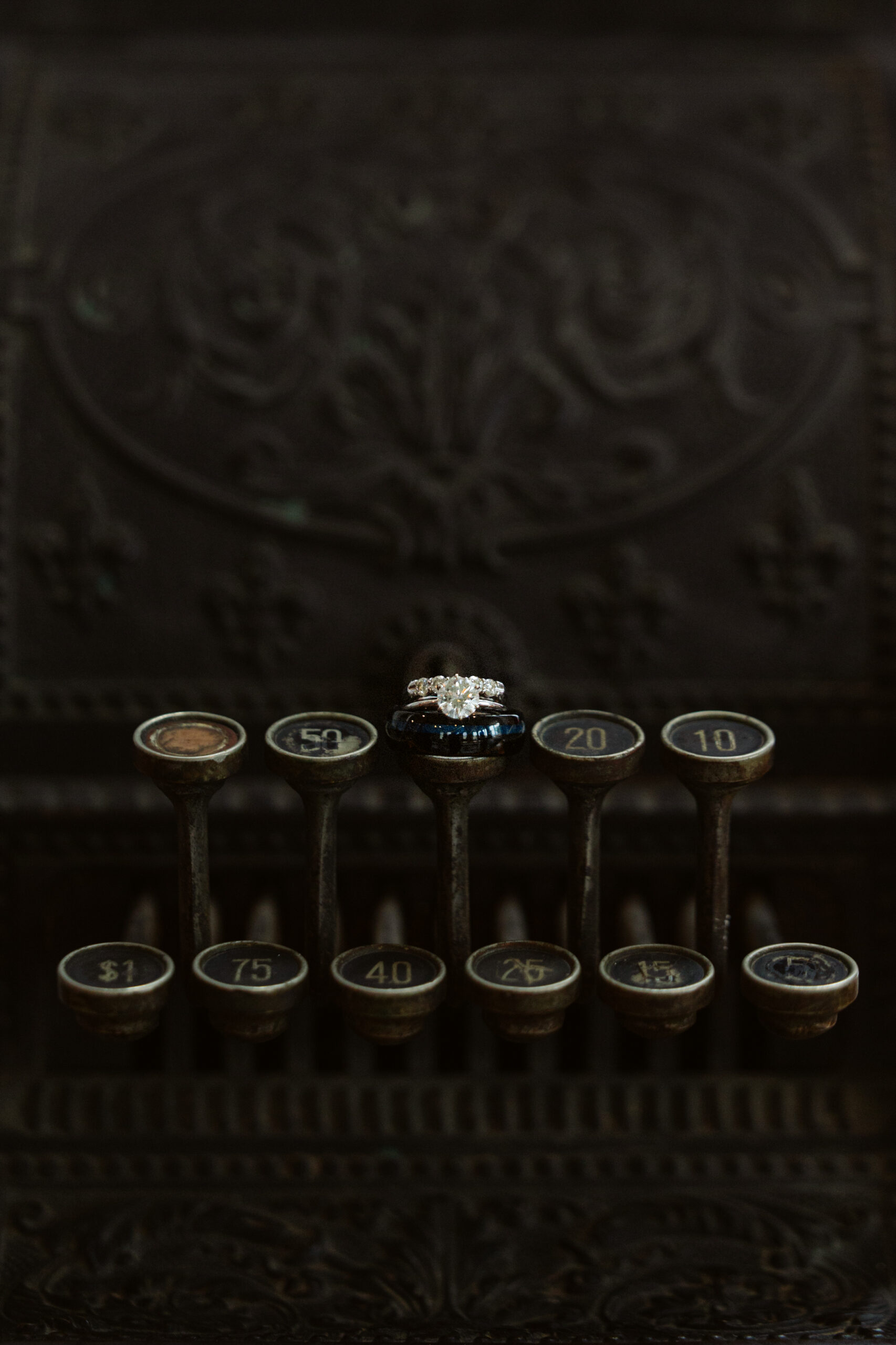 wedding rings sitting on vintage cash register at a general store at wedding in east jordan boathouse on lake charlevoix