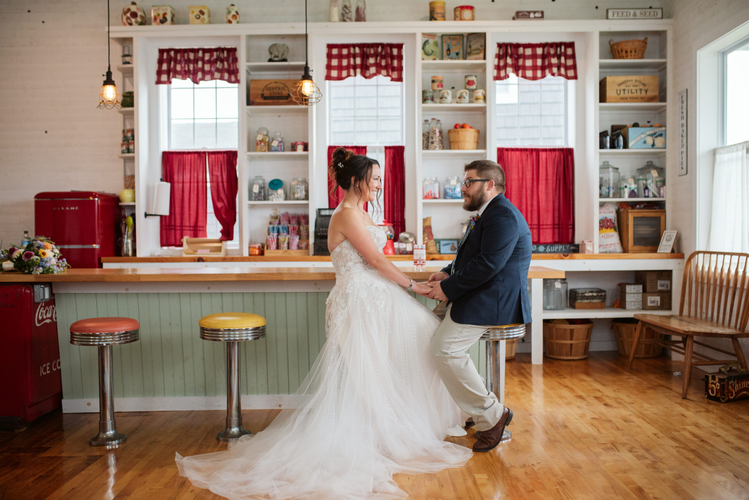 bride and groom holding hands at general store at wedding in east jordan boathouse on lake charlevoix