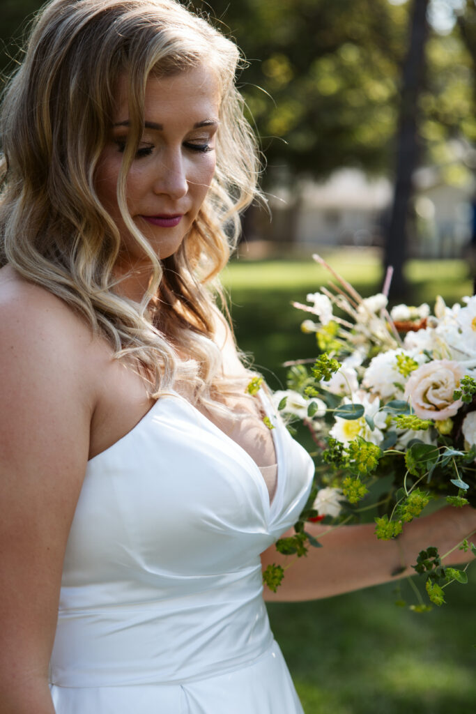 artistic image of bride backlit with flowers in glen arbor michigan wedding photo by traverse city wedding photographer and videographer
