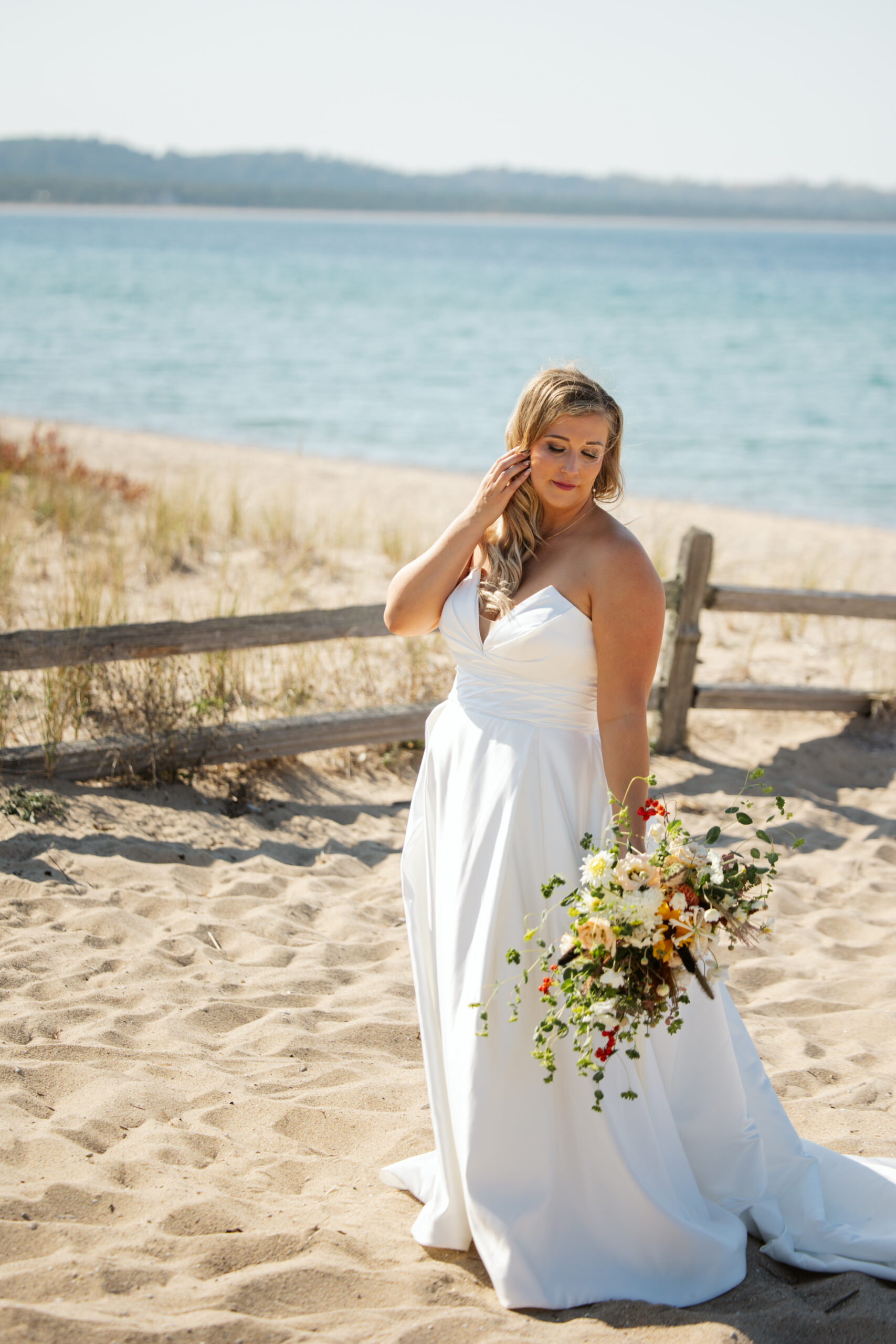 romantic portrait of bride on glen arbor lake michigan beach photo by traverse city wedding photographer
