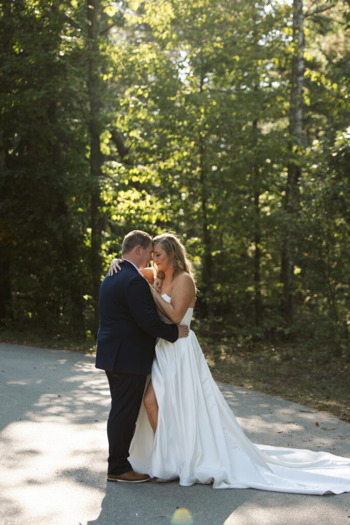 bride and groom standing in the road backlit in glen arbor park during wedding