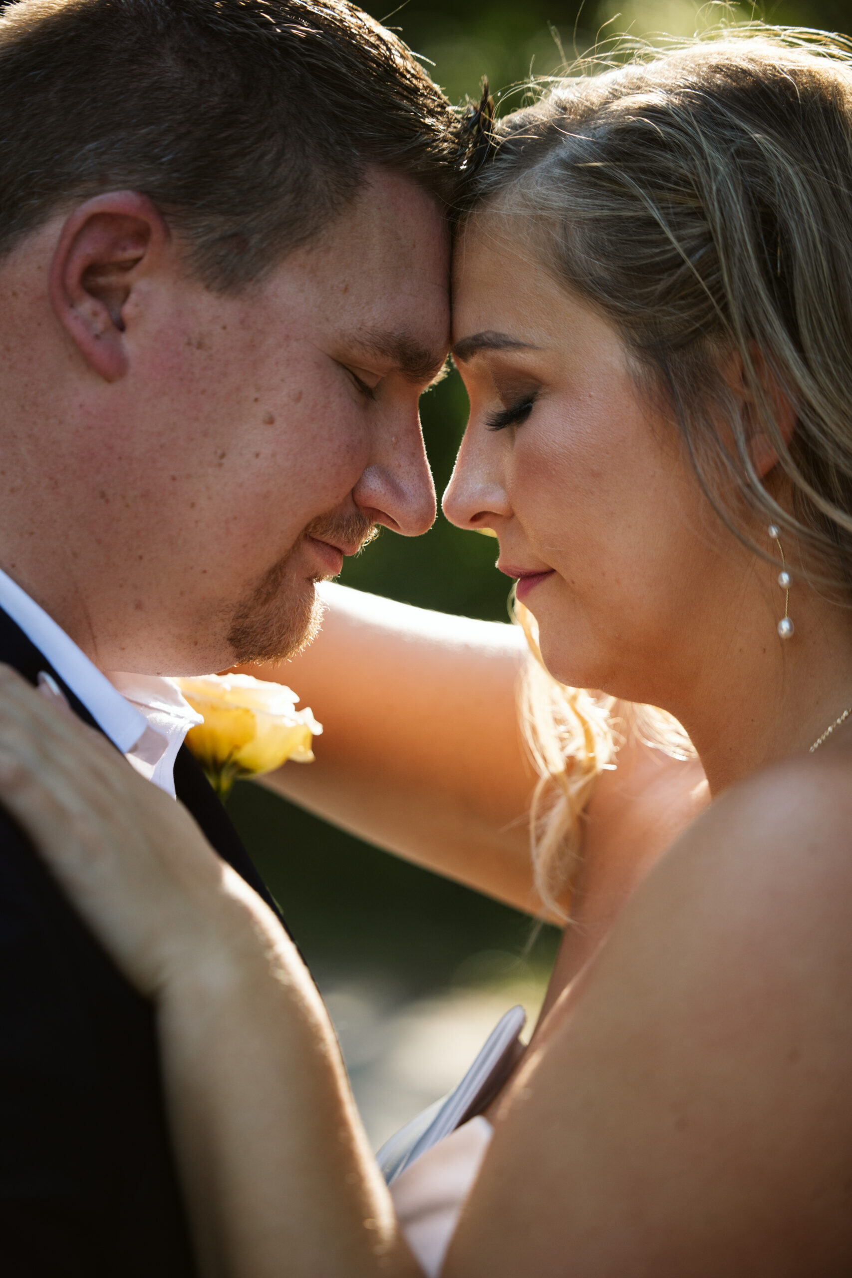 close up of bride and groom with foreheads together at wedding in glen arbor michigan photo by traverse city wedding photographer