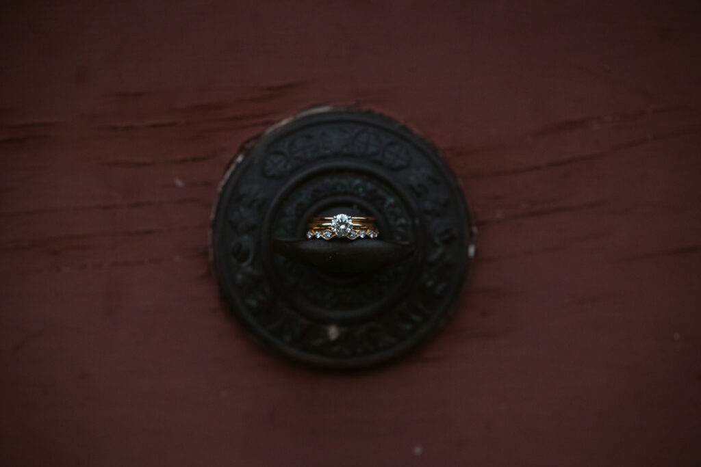 wedding ring sitting on vintage door bell at wedding in glen arbor michigan