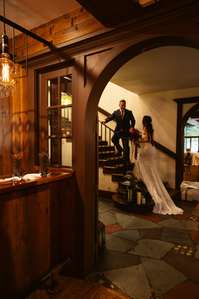 bride and groom walking up spiral stair case at peninsula cellars tavern mission table