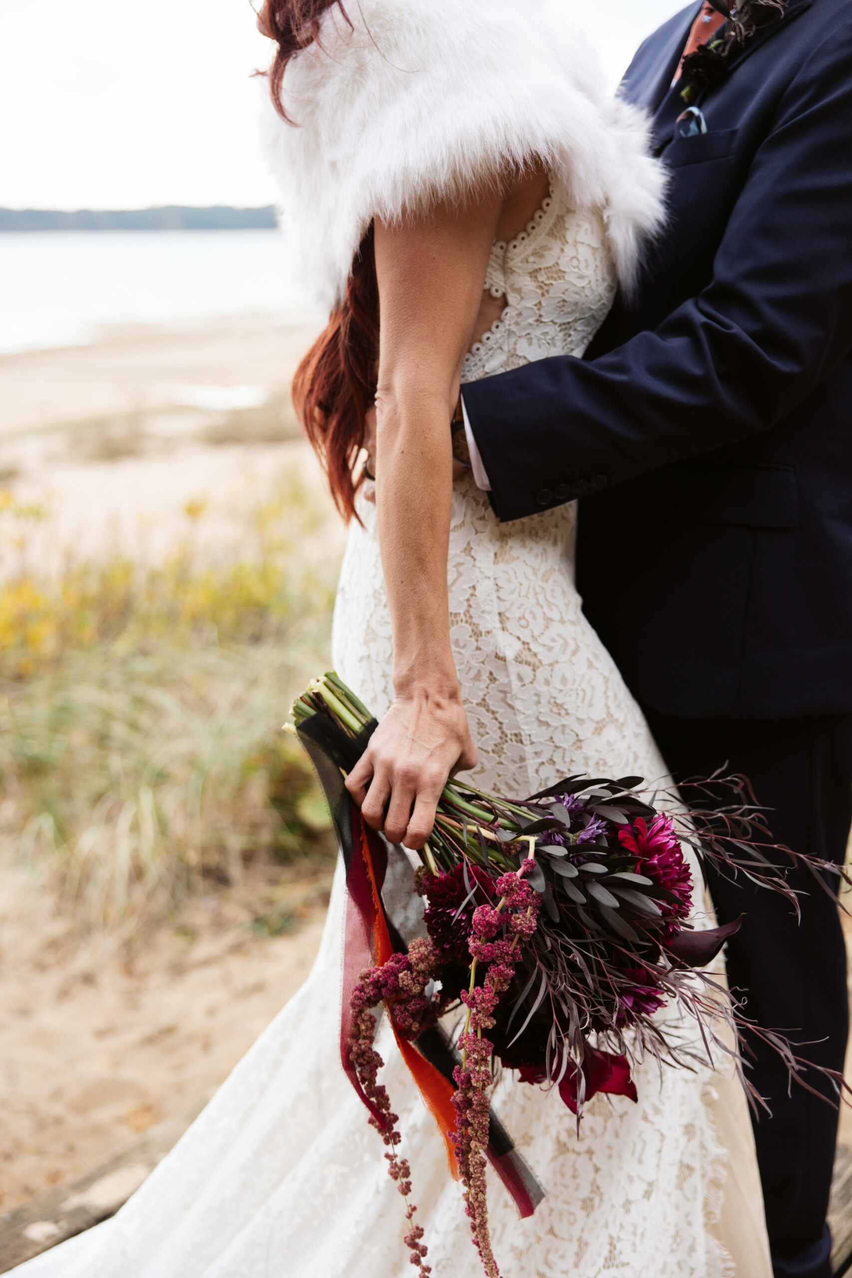 close up of bridal bouquet in the hand of a bride during wedding portraits at peninsula cellars in traverse city