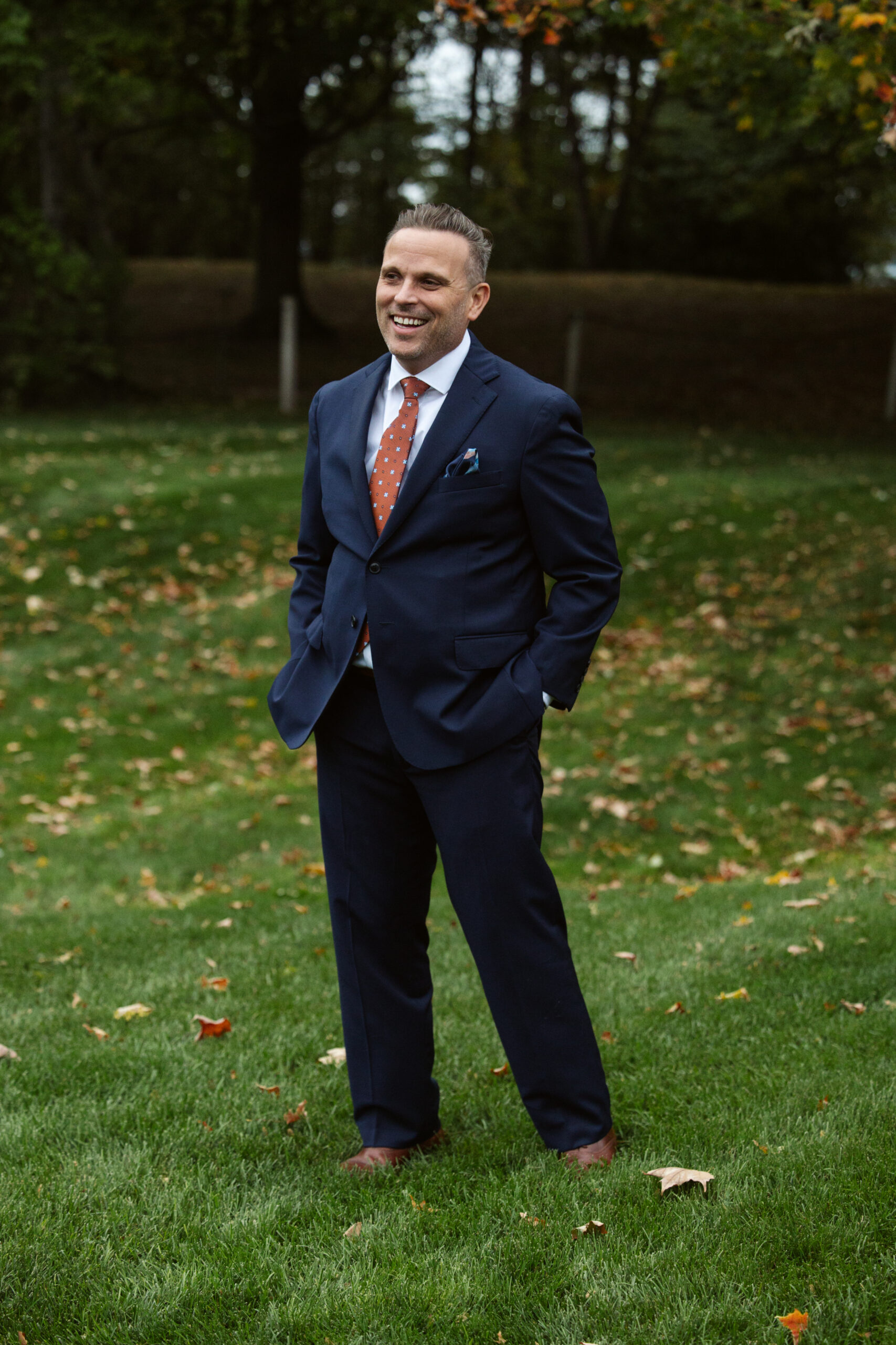 groom standing in the rain at peninsula cellars wedding venue in traverse city