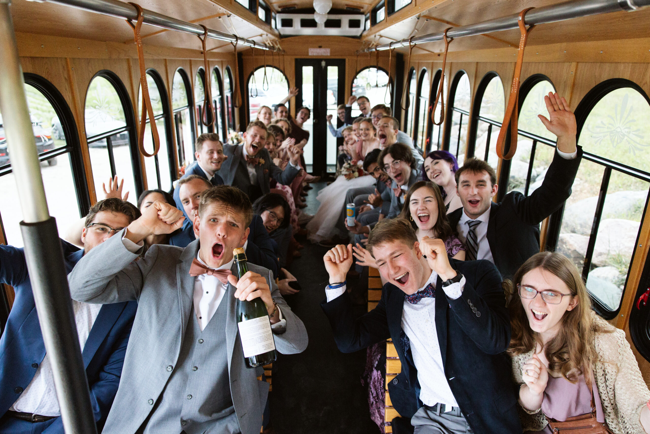 wedding trolly full of guests cheering on their way to starry night barn wedding reception
