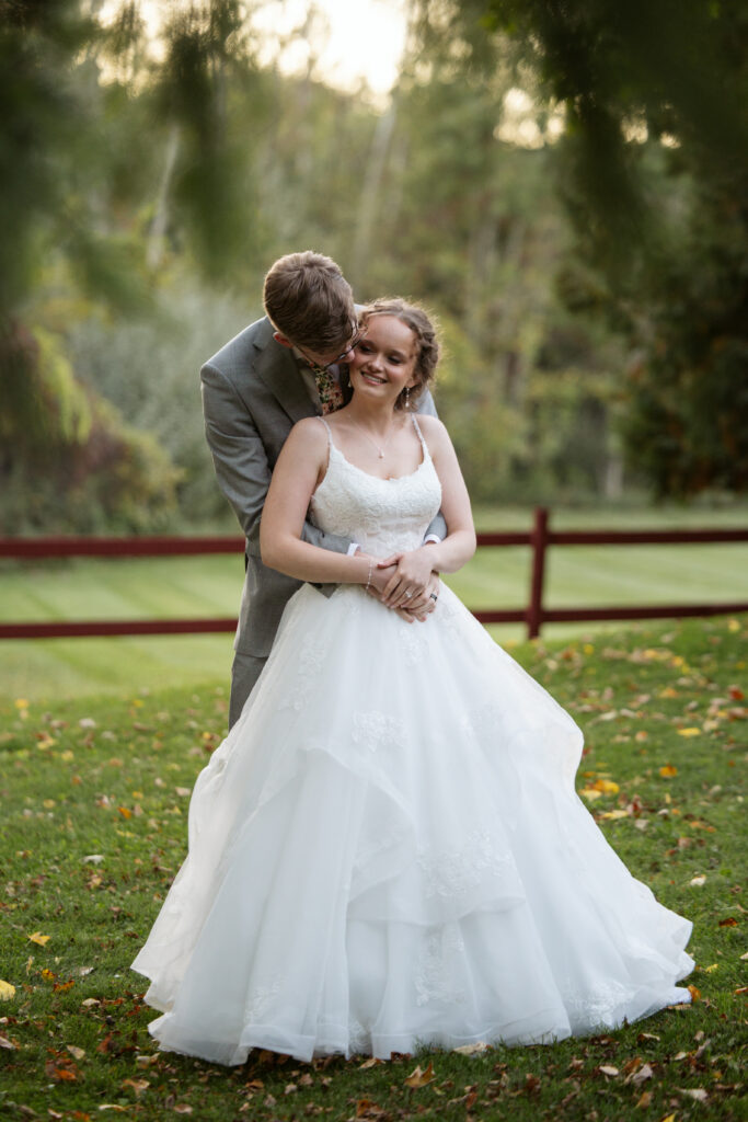 groom with his arms around his bride at starry night barn wedding in suttons bay michigan