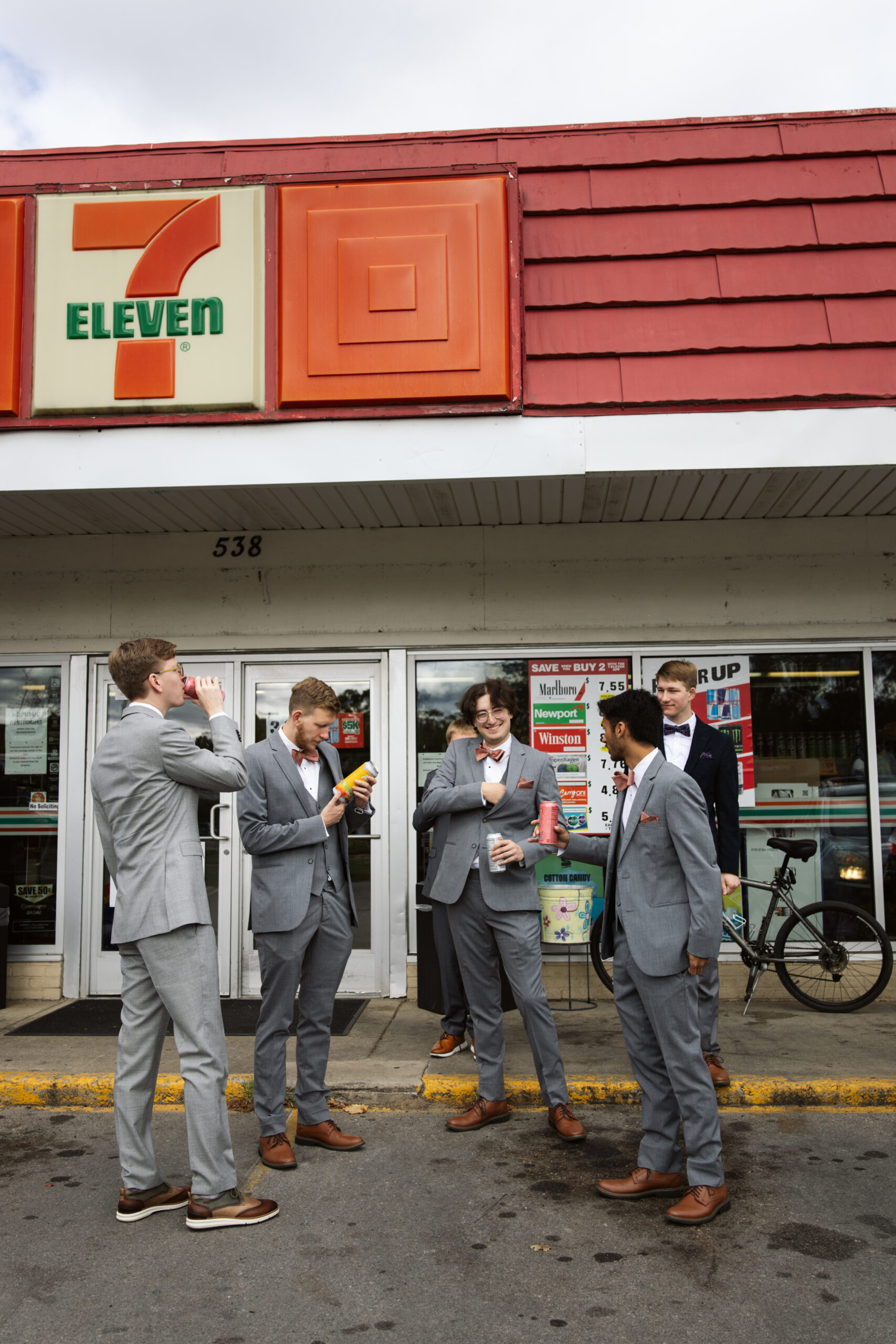 groom and groomsmen standing in front of a 711 in traverse city michigan