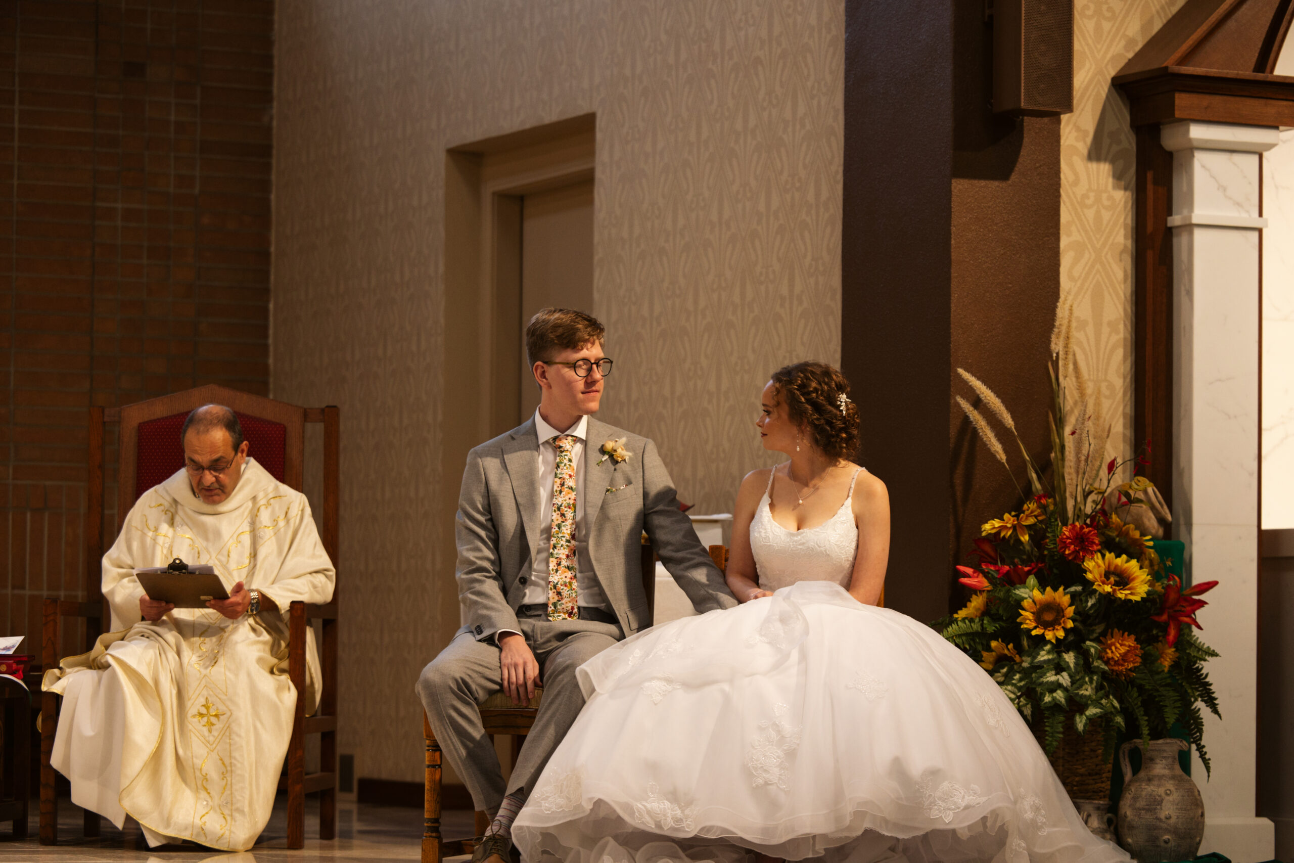bride and groom sitting ceremony at immaculate conception in traverse city
