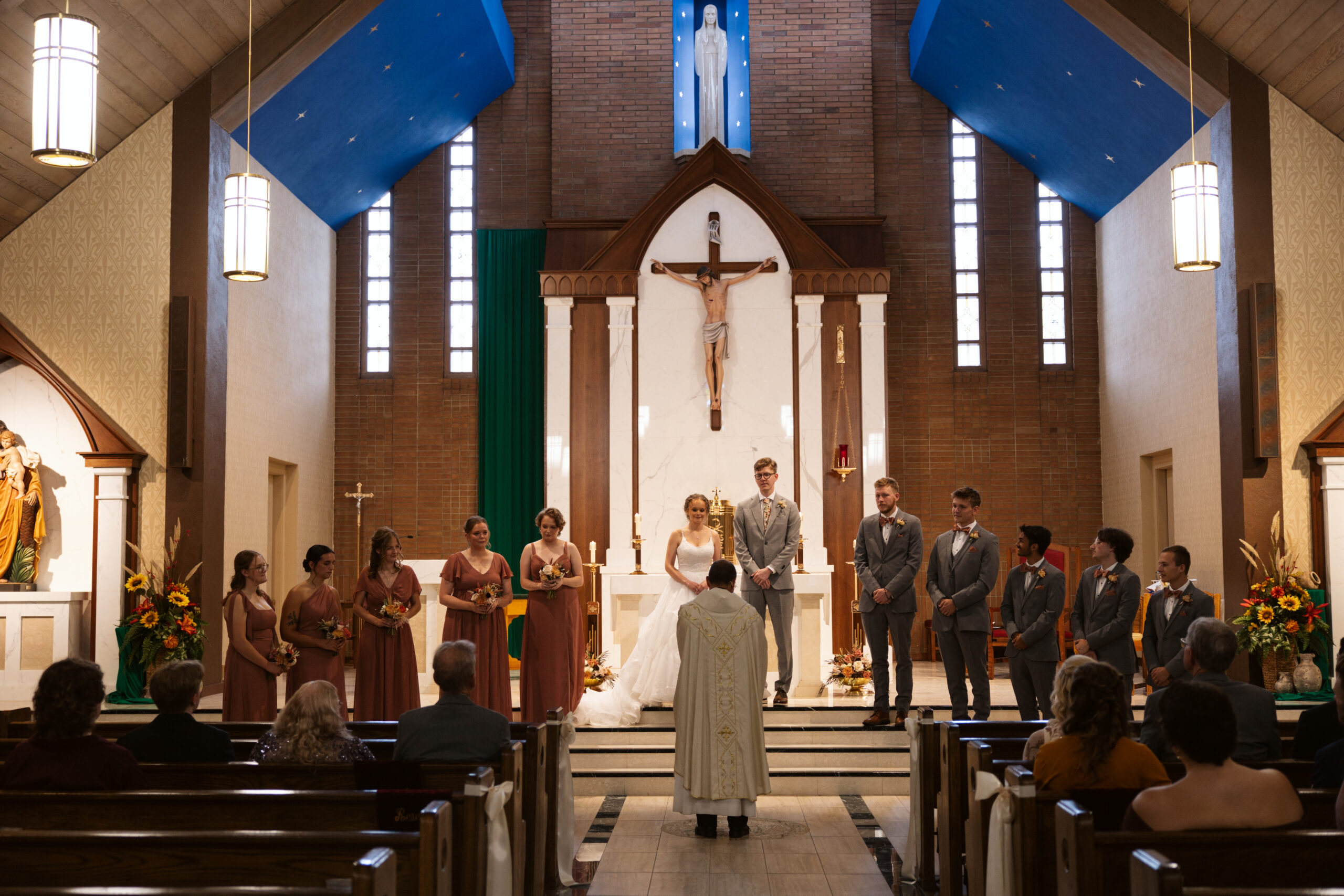bridal party standing at the front of a catholic church at immaculate conception