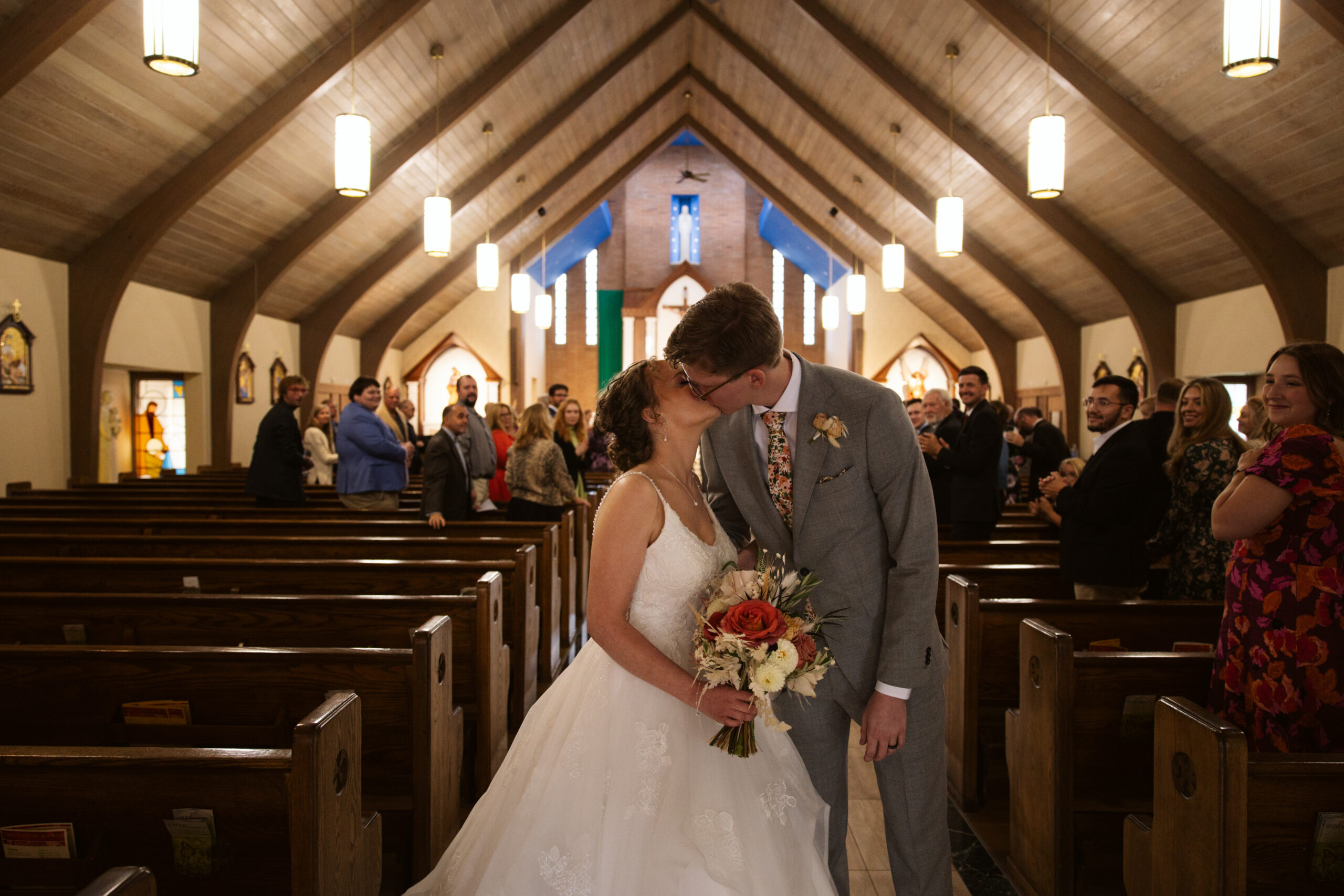bride and groom kissing after ceremony at immaculate conception in traverse city