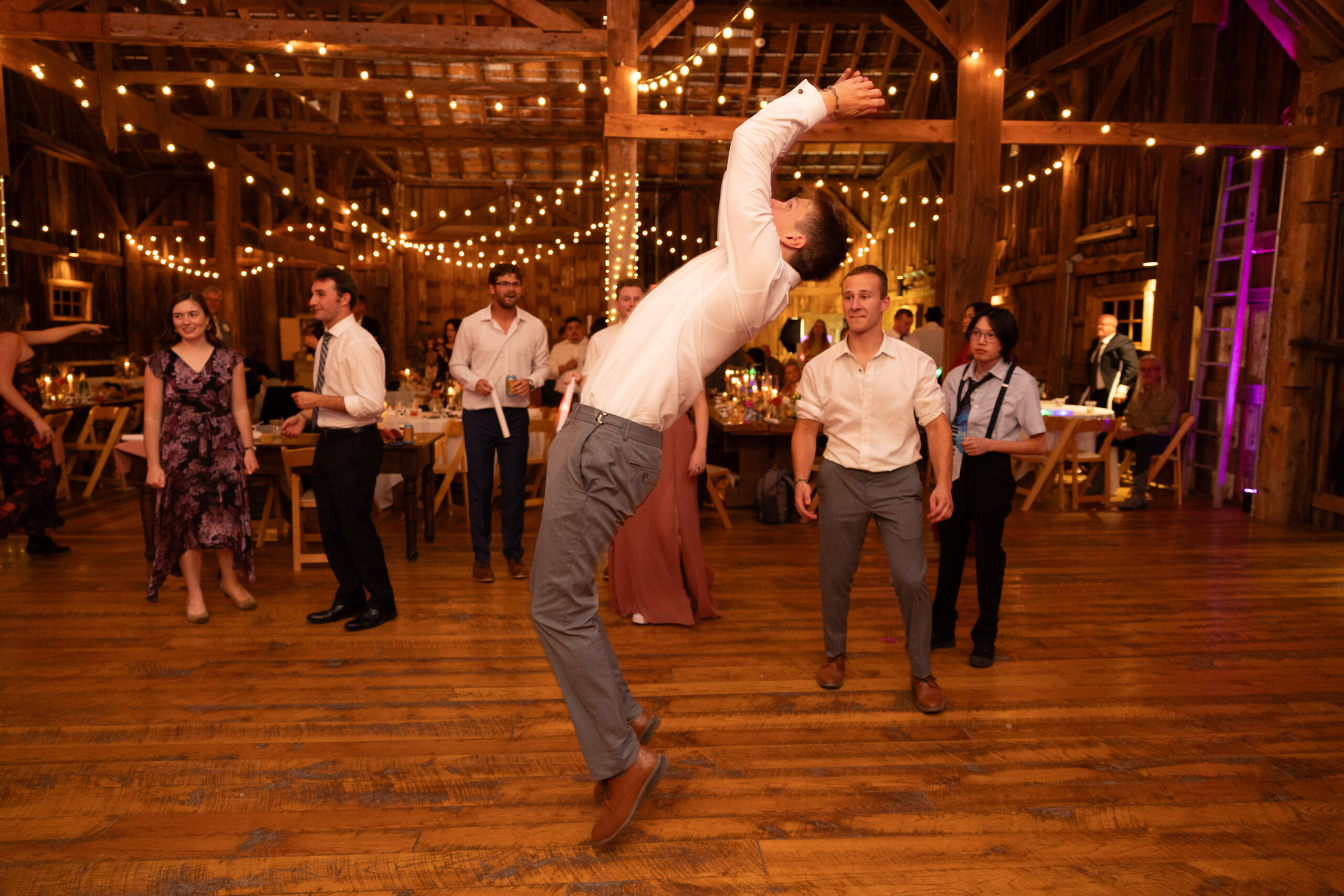 guest doing a backflip at a wedding reception at starry night barn in suttons bay michigan