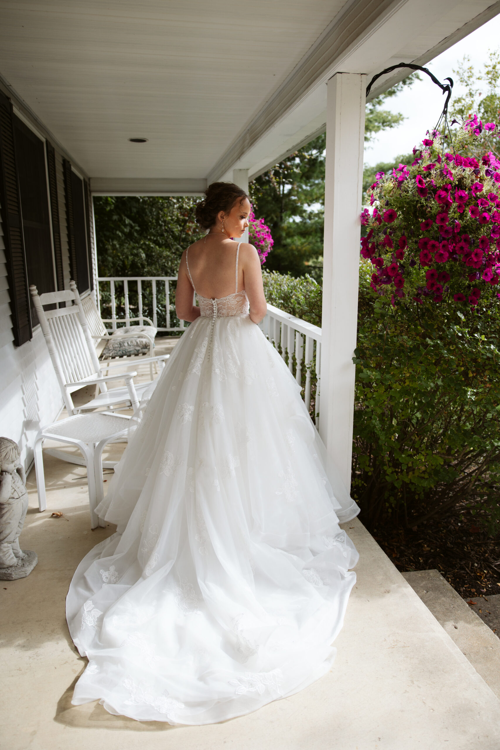 bride standing on the porch getting ready for her wedding at immaculate conception in traverse city michigan. photo by a traverse city wedding photographer