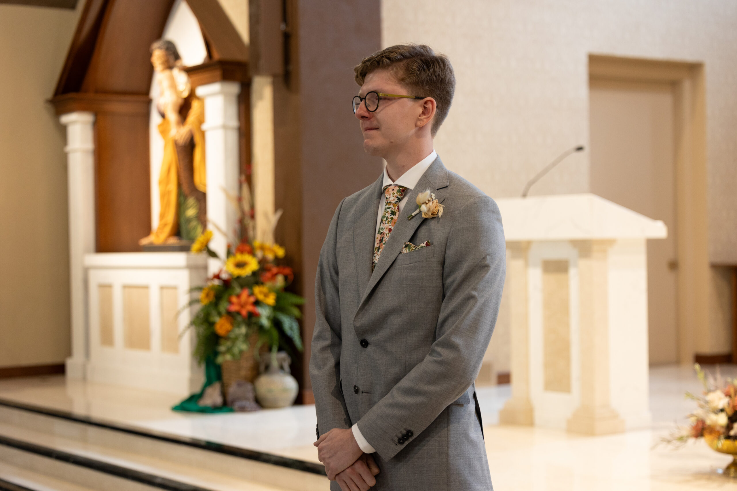 groom standing at the alter at immaculate conception in traverse city michigan