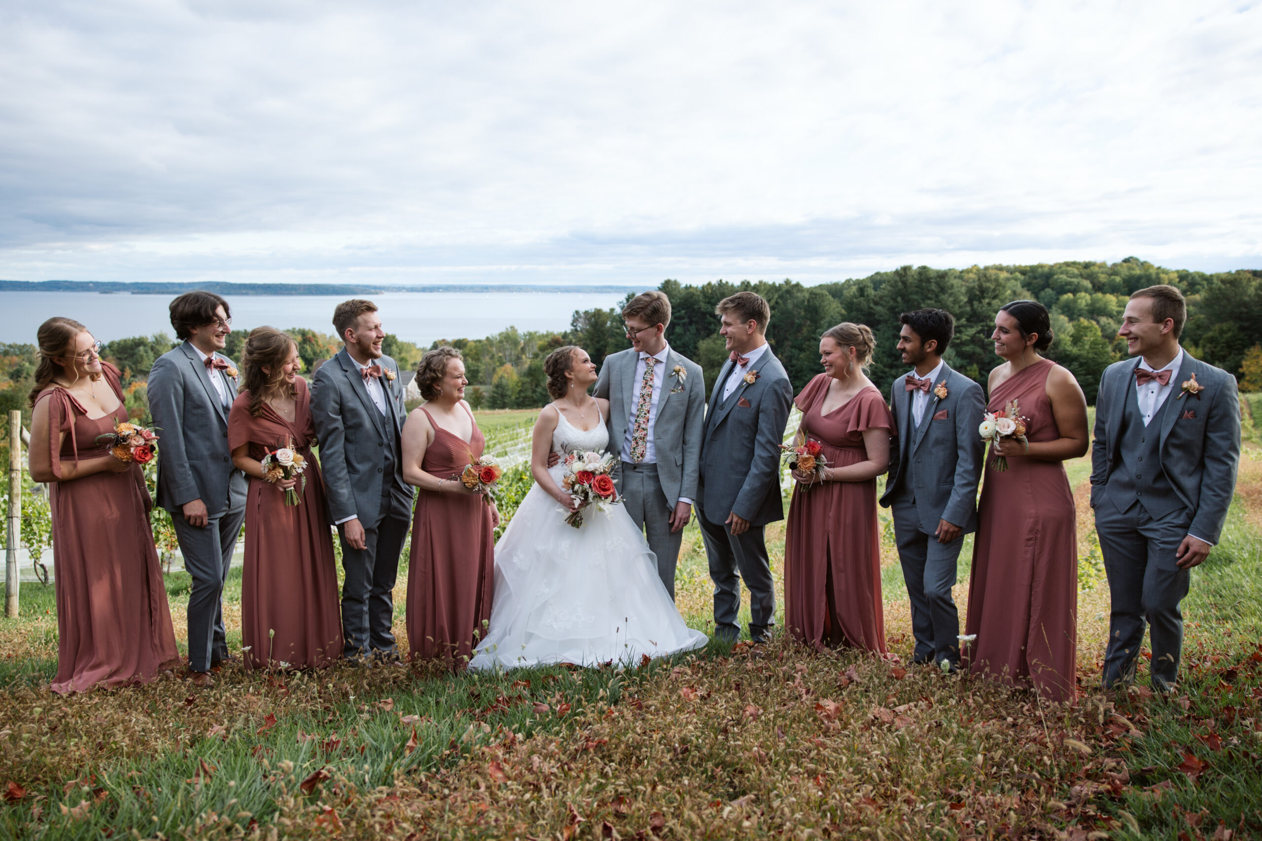 bridal party standing at the top of a vineyard in suttons bay