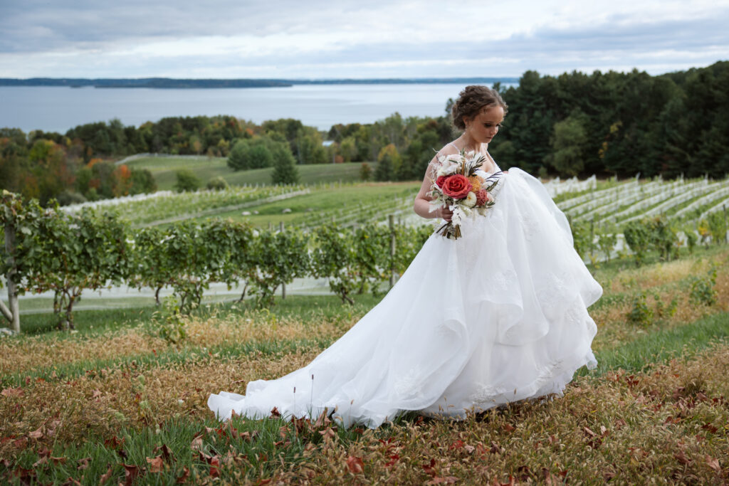 bride walking through vineyard at suttons bay michigan