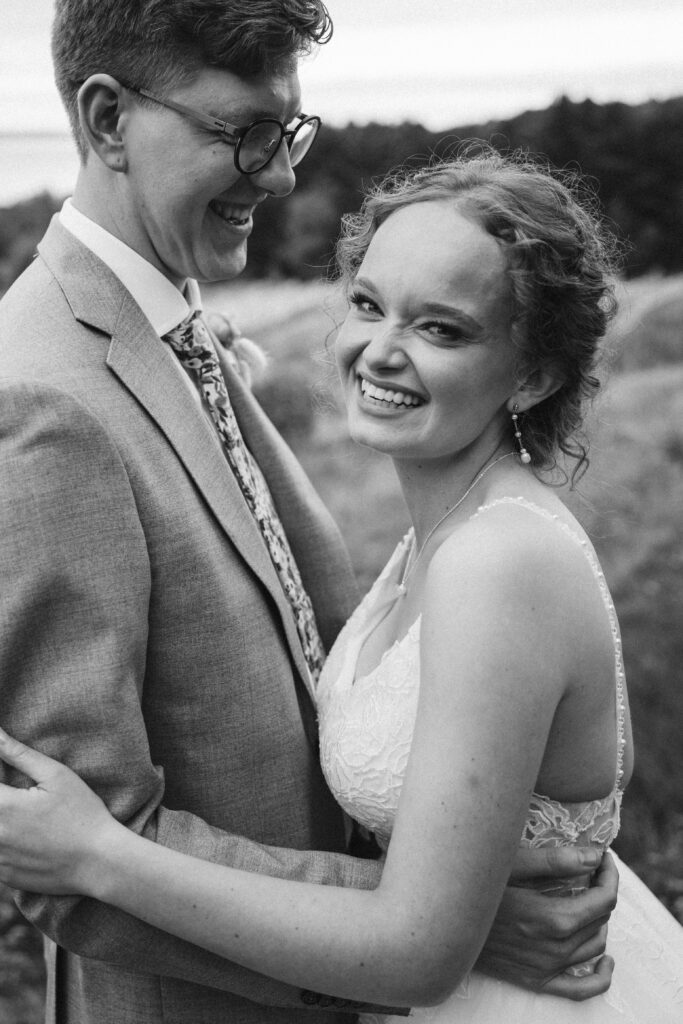 black and white bride laughing in the arms of her groom at vineyard in suttons bay michigan
