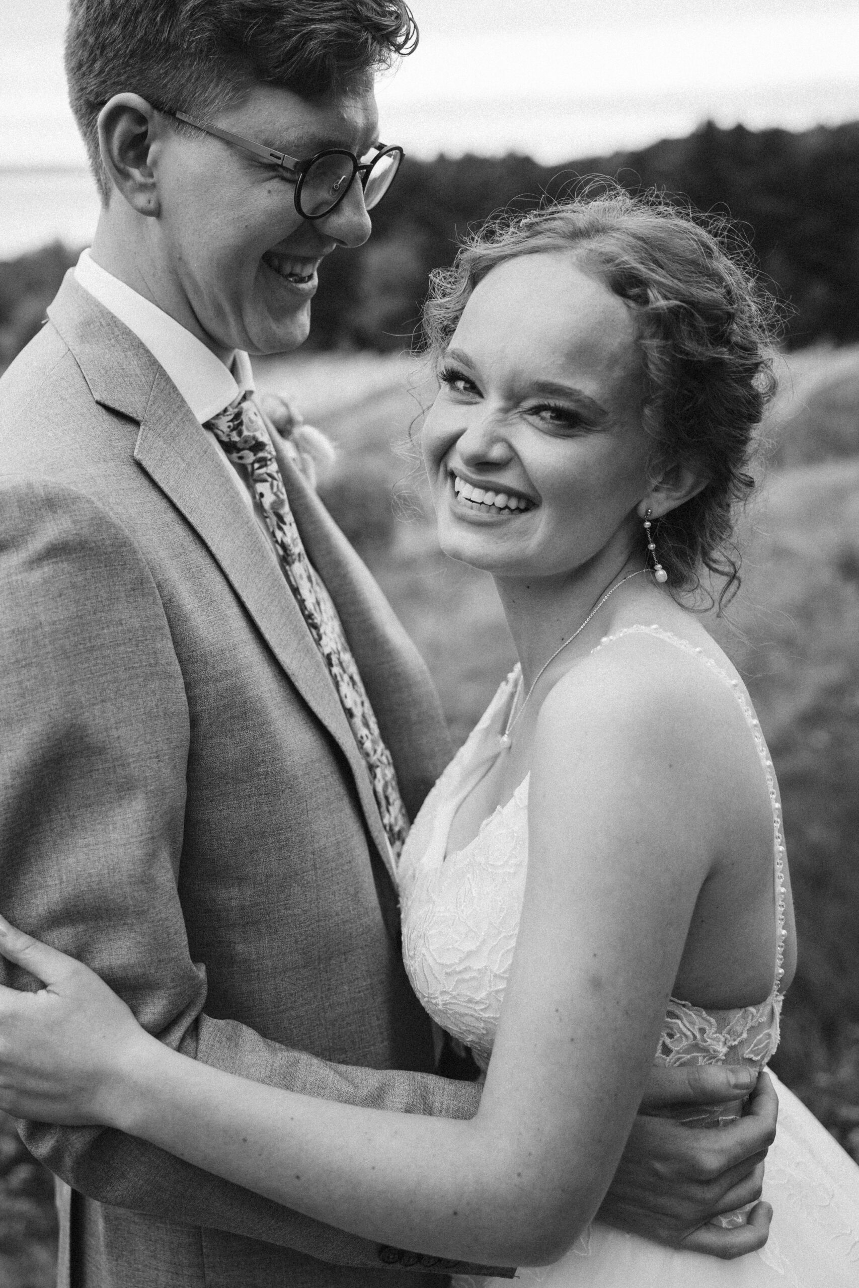 black and white bride laughing in the arms of her groom at vineyard in suttons bay michigan