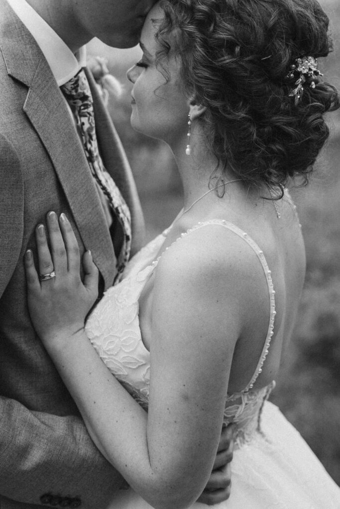 black and white close up of bride and groom going in for a kiss at vineyard in suttons bay