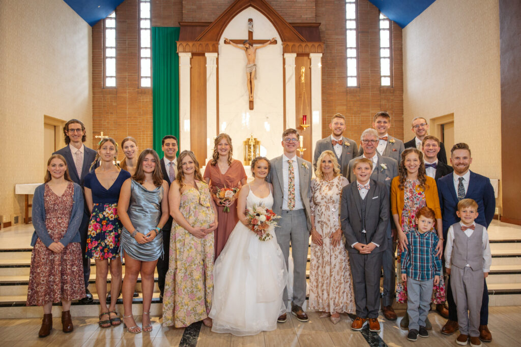 bride and groom and family during family formals at immaculate conception catholic church in traverse city