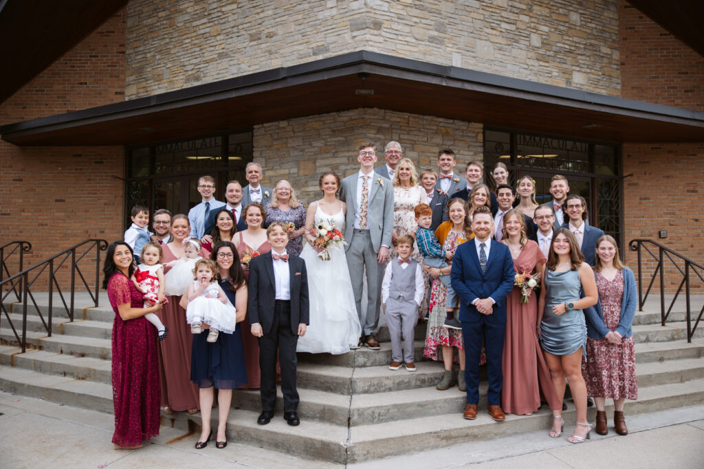 bride and groom and family during family formals at immaculate conception catholic church in traverse city 