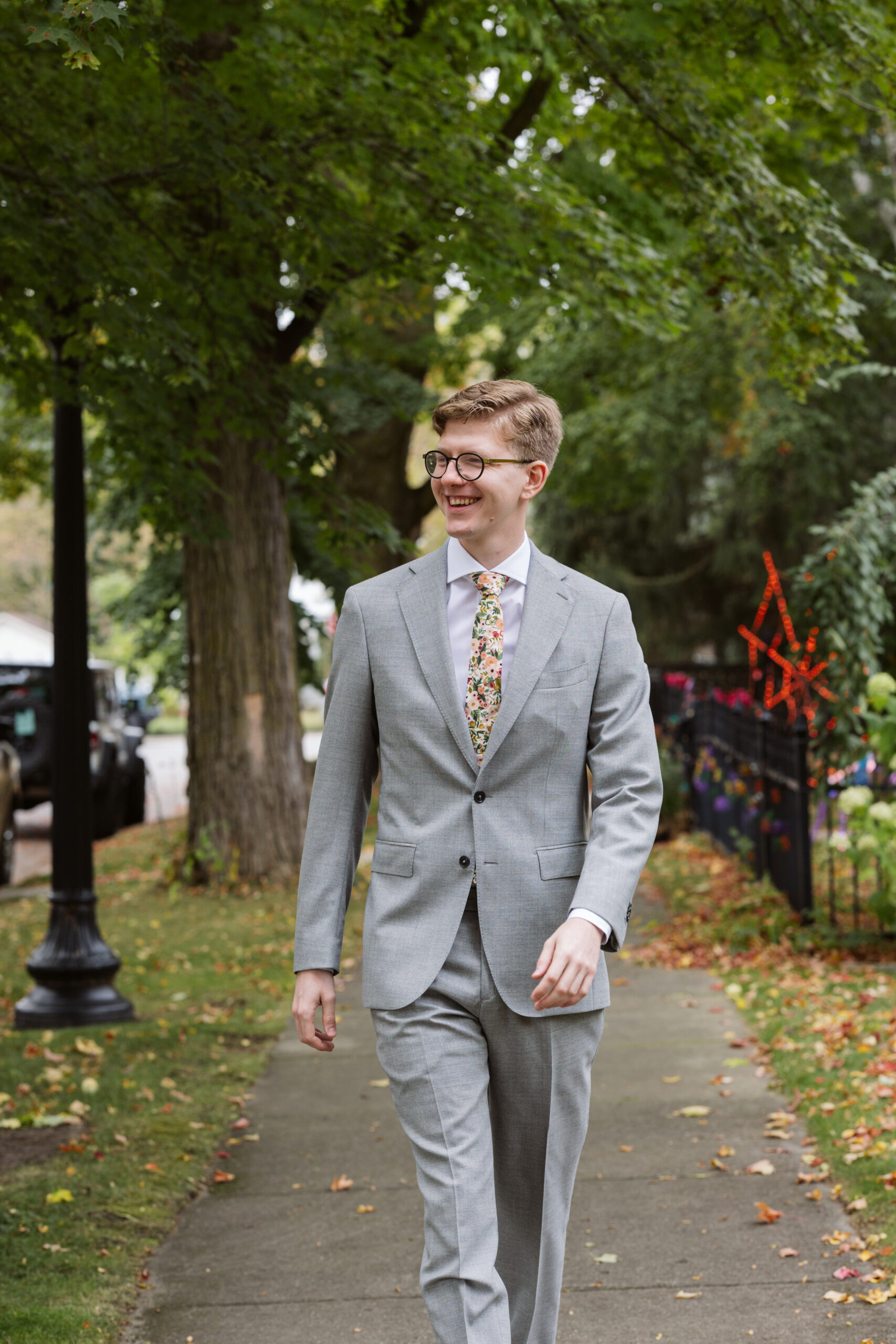 groom walking down sidewalk in traverse city michigan wedding