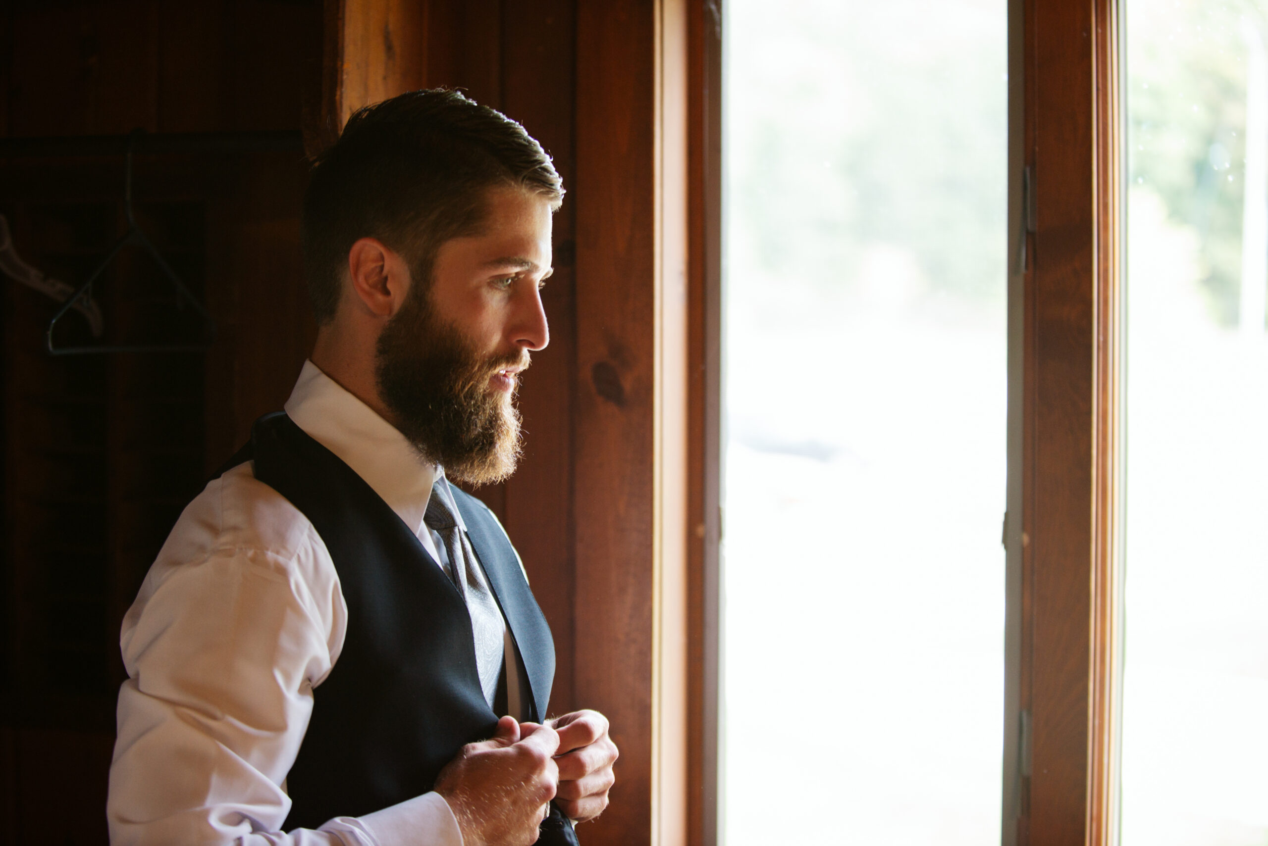 groom looking out window during wedding at twin lakes campground in traverse city
