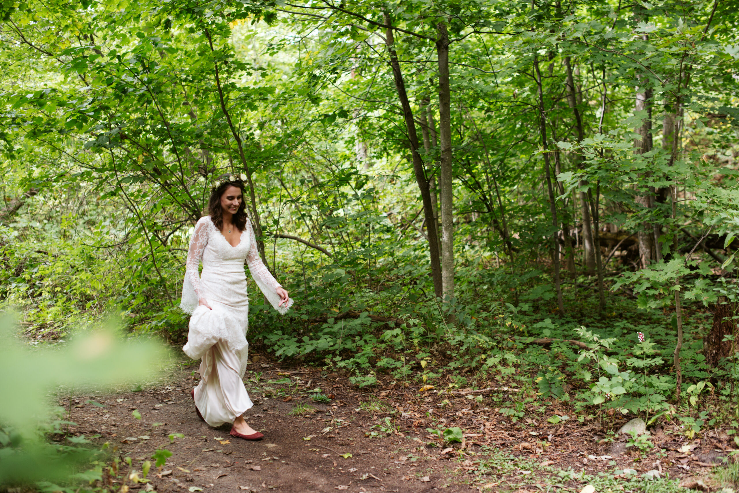 bride walking in woodds during wedding at twin lakes campground in traverse city