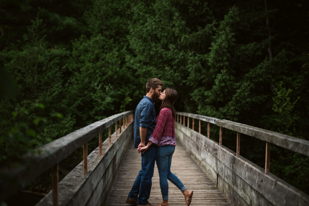 man and woman standing on a bridge during traverse city engagement session