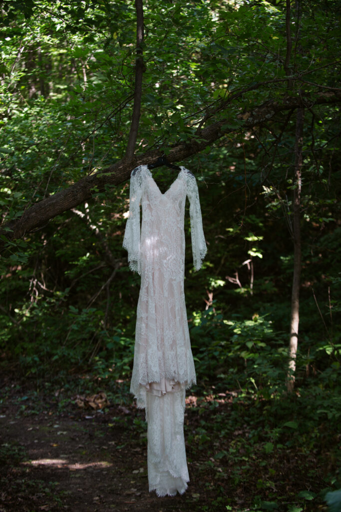 wedding dress hanging from a tree during wedding at twin lakes campground in traverse city