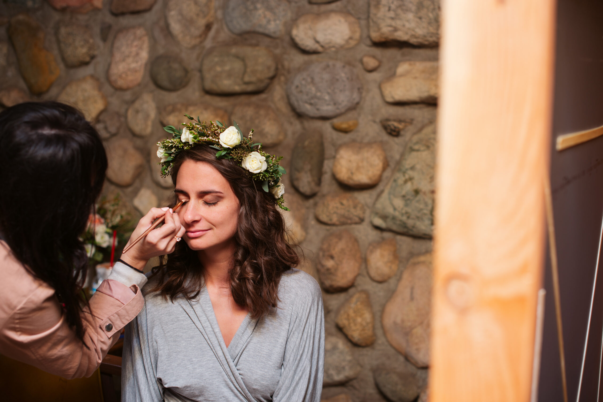 bride getting makeup done during wedding at twin lakes campground in traverse city