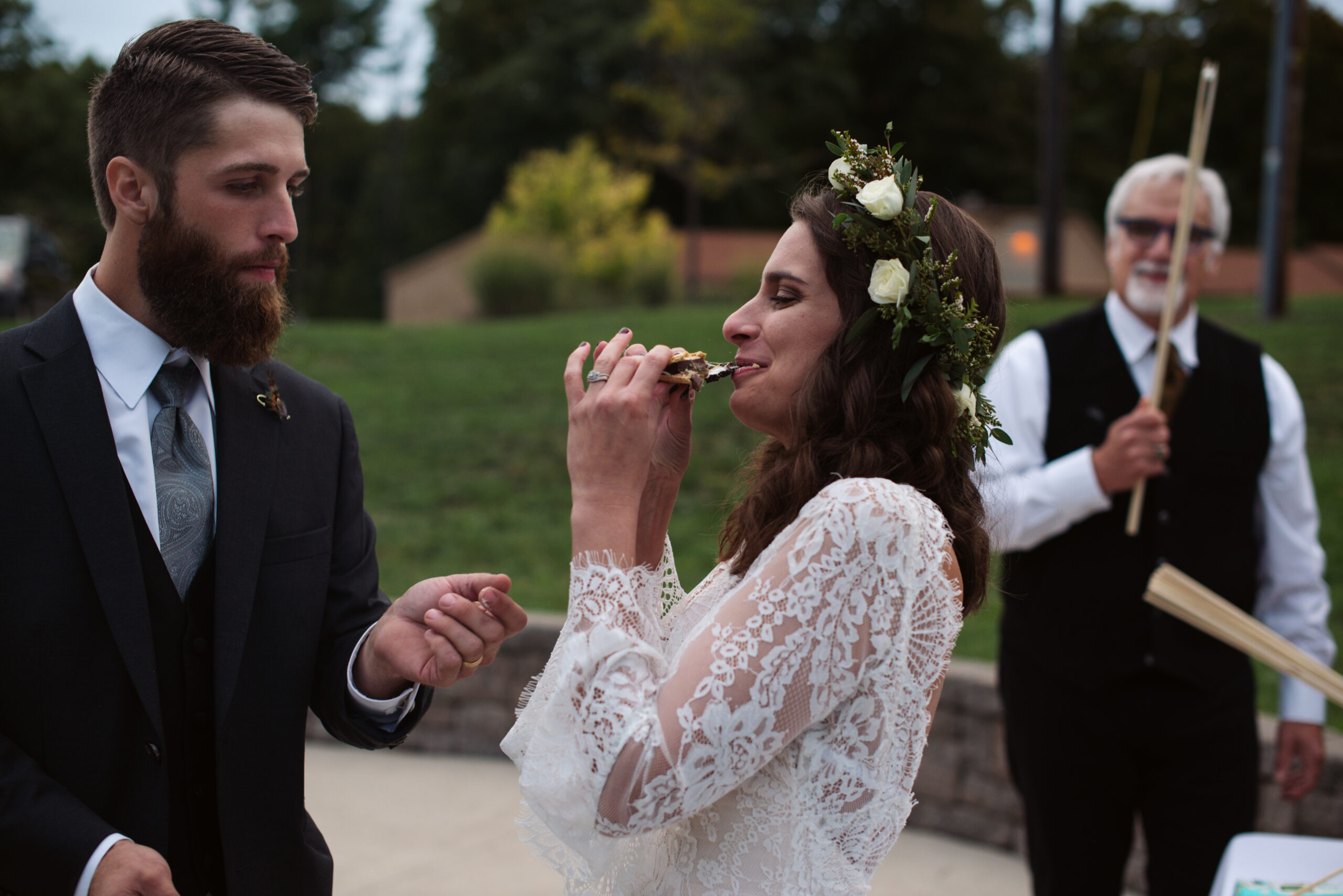 bride eating a smore during wedding at twin lakes campground in traverse city