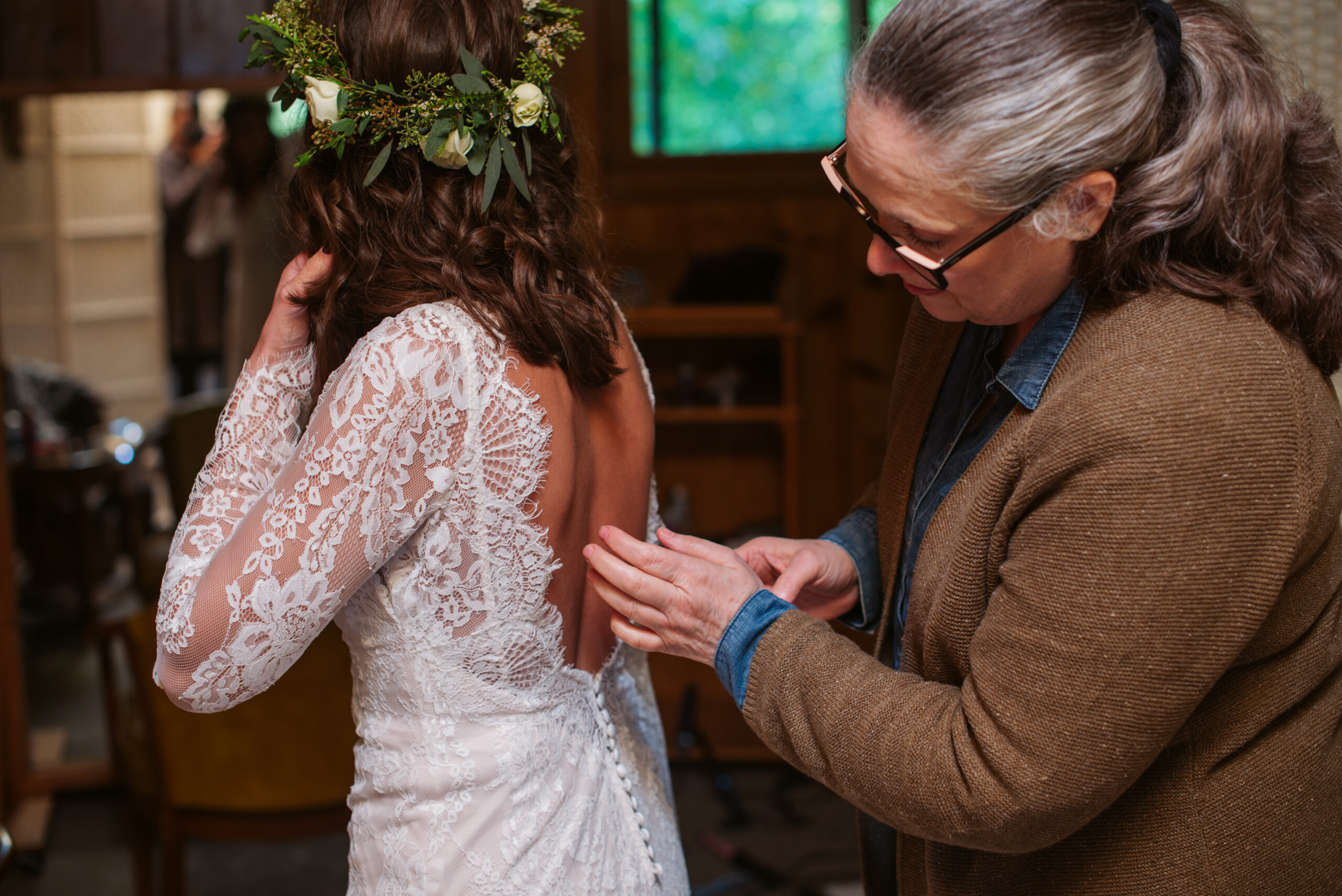 bride getting her dress on during wedding at twin lakes campground in traverse city