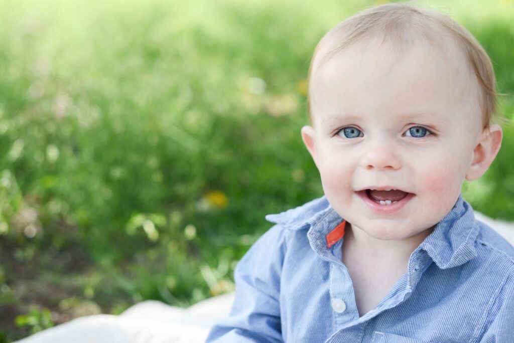 little boy sitting in field during spring family photos on old mission peninsula michigan