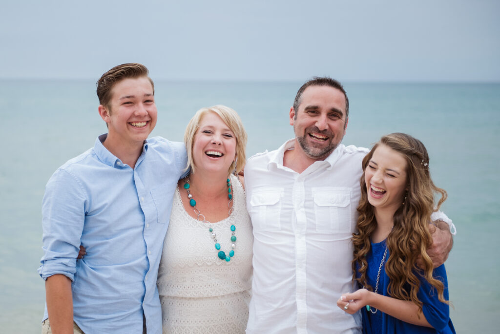 family on lake michigan beach taking family photos with traverse city photographer