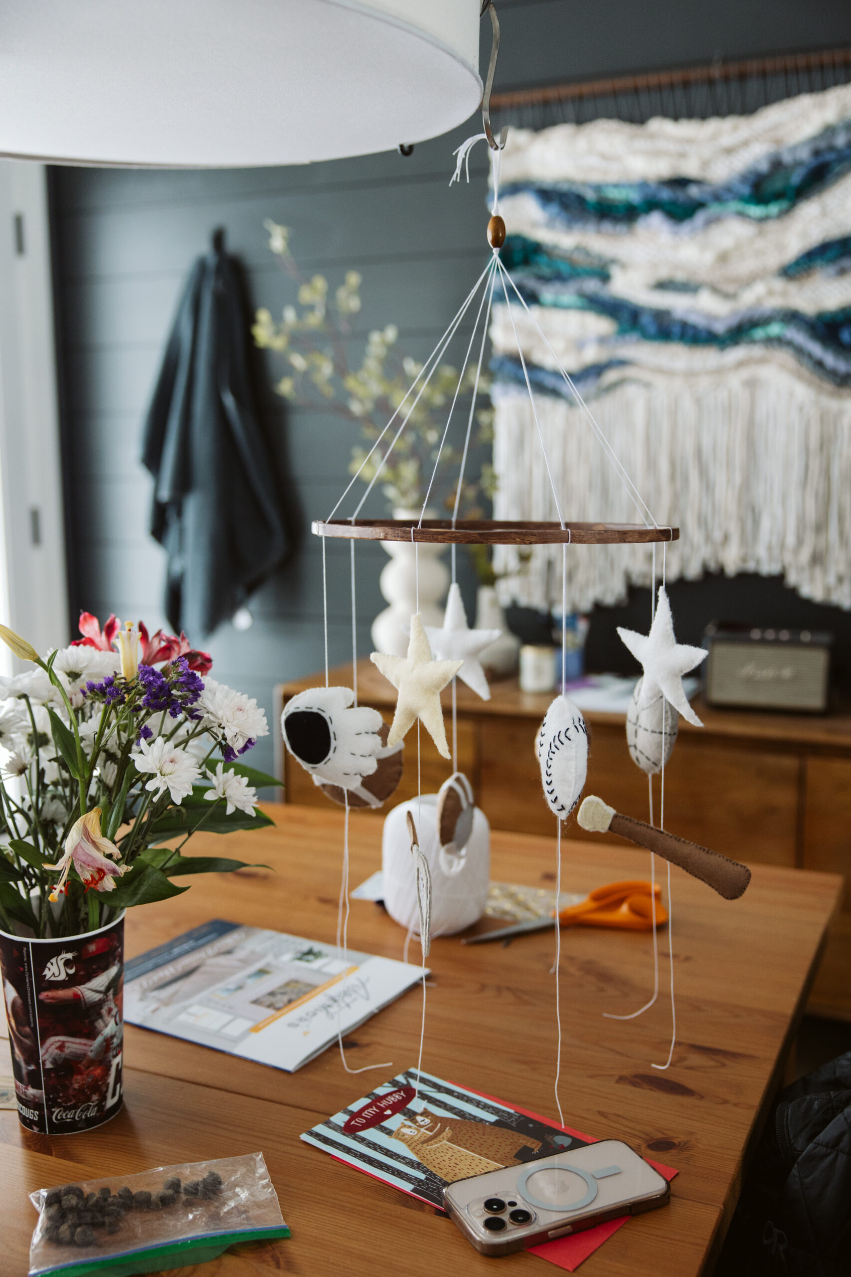 baby mobile hanging in kitchen durning home maternity photos in traverse city michigan