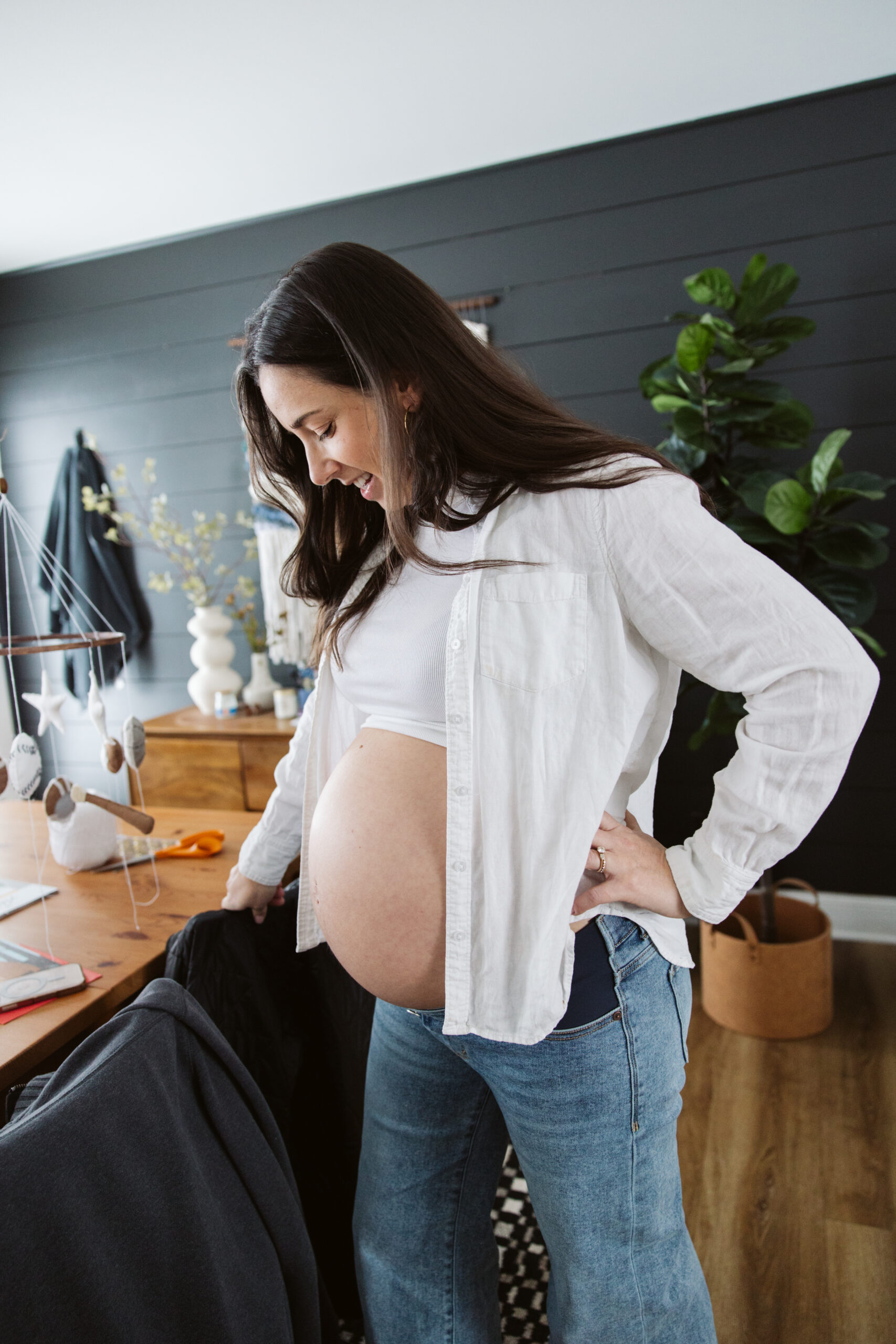 pregnant woman standing in kitchen durning home family photos in traverse city michigan