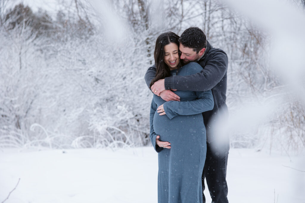 standing in snow during maternity session in traverse city michigan